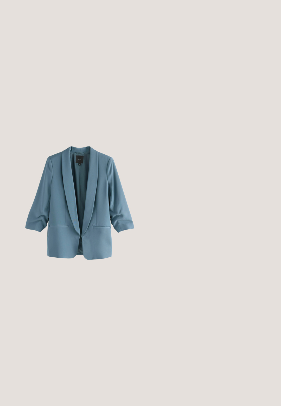 Lichtblauwe blazer met een sjaalkraag, driekwart mouwen, twee voorzakken en een gladde, gestructureerde stof.; Korte mouwen blouse in marineblauw, lichtblauw en groen. Heeft abstracte cirkelpatronen en een relaxte pasvorm met een ronde halslijn.; Blauwe gebreide trui boven hooggetailleerde, geplooide, lichtgrijze broeken. De broeken hebben een platte tailleband met lussen voor een riem en zijzakken.; Suède pumps in teal met een spitse neus en een stevige blokhak. De buitenkant is glad en toont een minimalistisch ontwerp.; Lichtgrijze leren crossbodytas met verstelbare riem, voorvak met rits en gouden "LASOCKI"-logo op een gladde, gestructureerde oppervlakte.; Gouden ketting met een fijne ketting en een druppelvormig hanger van donker groen gesteente, met een glad oppervlak en een gepolijste afwerking.