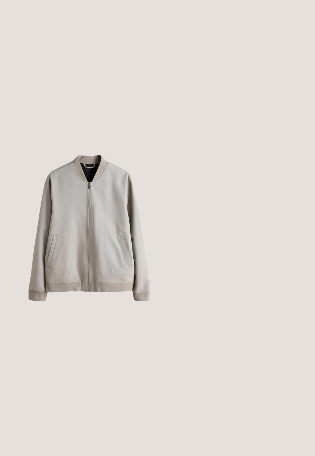 Veste bomber gris clair avec une surface texturée, des poignets côtelés et un intérieur noir. Comprend des poches latérales et une fermeture éclair frontale.; Sweat-shirt beige à manches longues avec col rond, poignets et ourlet côtelés, présenté sur fond blanc uni.; T-shirt en coton beige avec un col rond, des manches courtes et une coupe droite. Texture lisse et sans motifs ni accents visibles.; Pantalon beige droit avec bouton et fermeture éclair à l'avant, passants de ceinture, poches latérales et petite poche à monnaie sur le côté gauche.; Baskets blanches basses à lacets sur l'avant avec semelle en caoutchouc texturée, sur fond neutre uni.; Sac cabas en toile beige avec deux anses et une poche avant, "LES DEUX" brodé sur la poche.