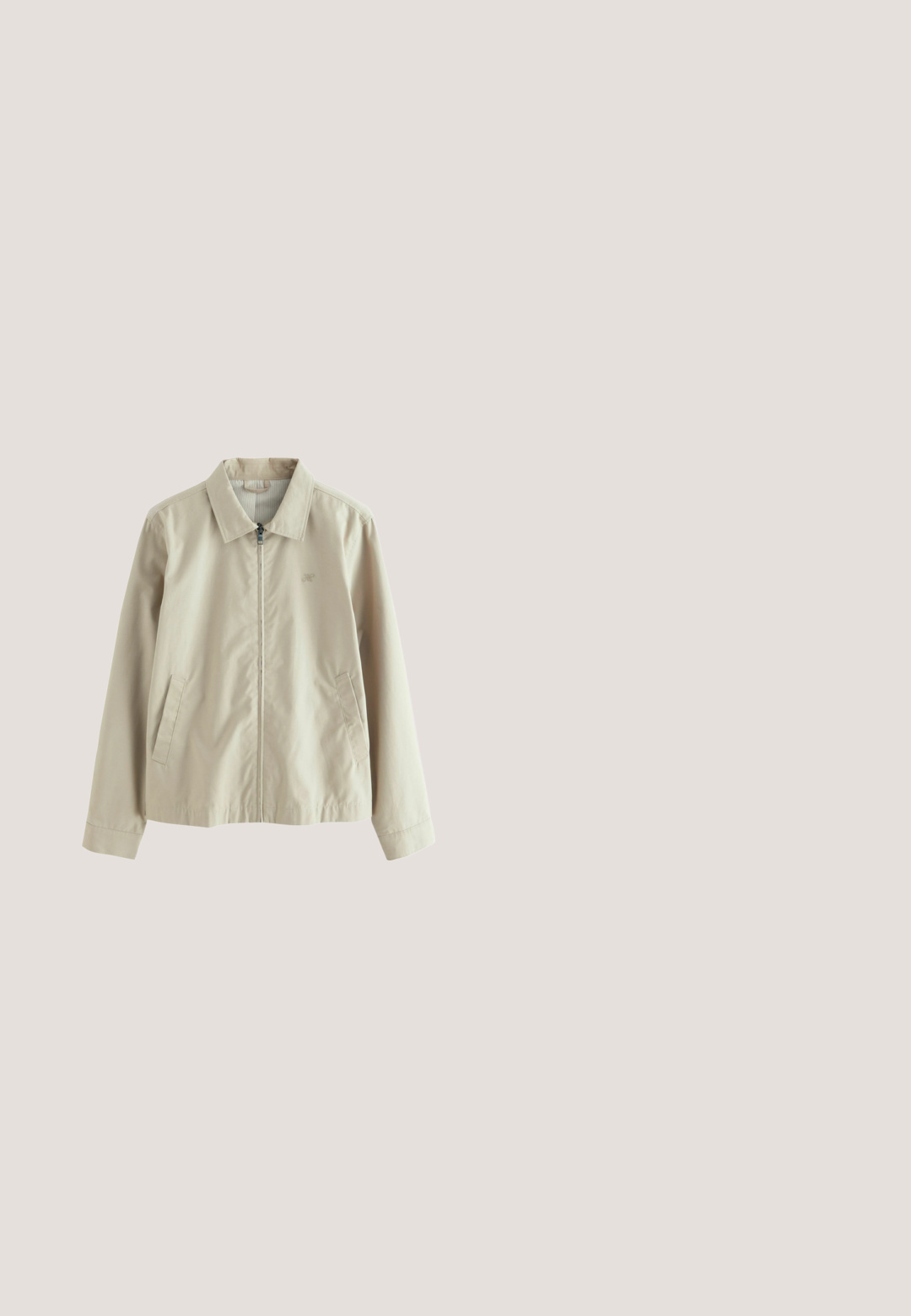 Lys beige stof med en glat tekstur; har et diskret broderet logo og en sølvfarvet lynlås ved kraven.; Lysegrå sweatshirt med lange ærmer og rund hals, med ribstrikkede manchetter og kant, ensfarvet blødt stof, ingen synlige mønstre eller logoer.; Enkelt hvid T-shirt med korte ærmer og rund hals, løs pasform og uden synlige logoer eller designs foran.; Beige bukser med lige ben, knap- og lynlåslukning, bæltestropper og sidelommer, lagt fladt på en hvid baggrund.; Hvide lædersneakers med hvide snørebånd, præsenteret på en beige tekstureret overflade og med en blødt uskarp baggrund.; Kremfarvet lærredstote-taske med frontlomme, to håndtag, justerbar skulderrem og lille gul "O.N.S" tekst i nederste højre hjørne af lommen.