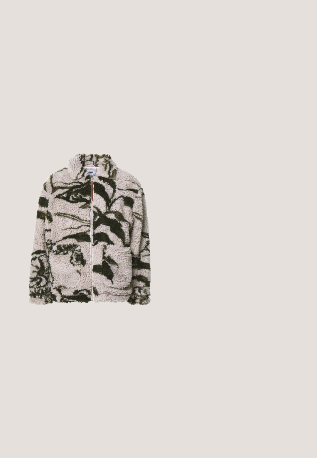 Fleece-tyynysatula beige-värissä, jossa on vihreitä kukkakuvioita, sisältää kaksi etutaskua, korkean kauluksen ja pehmeän, tekstuurisen kankaan.; Tummanpunainen huppari, jossa etutasku, koristeltu värikkäällä hahmografiikalla ja tekstillä "Volcom." Valmistettu pehmeästä kankaasta.; Harmaa Levi's t-paita, jossa mustalla viivalla piirretty ruusu ja teksti "PERMANENT" sekä tyylitelty "LIFETIME" edessä, lyhyet hihat, pyöreä kaula-aukko.; Väljänt malliset tummanoliivinvihreät housut, joissa on joustava vyötärö, näkyvät saumaraot ja sivutaskut, esitetty yksinkertaisella vaalealla taustalla.; Ruskean mokkanahkaiset nilkkurit mustilla nahkakorostuksilla, pyöreä kärki, nauhakiinnitys ja kestävä musta kumipohja. Sivulla logo.; Ruskea kangaskassi, jossa on kaksi vetoketjullista taskua, säädettävät hihnat ja logotarra edessä. Sileä pinta, suorakulmainen muoto.