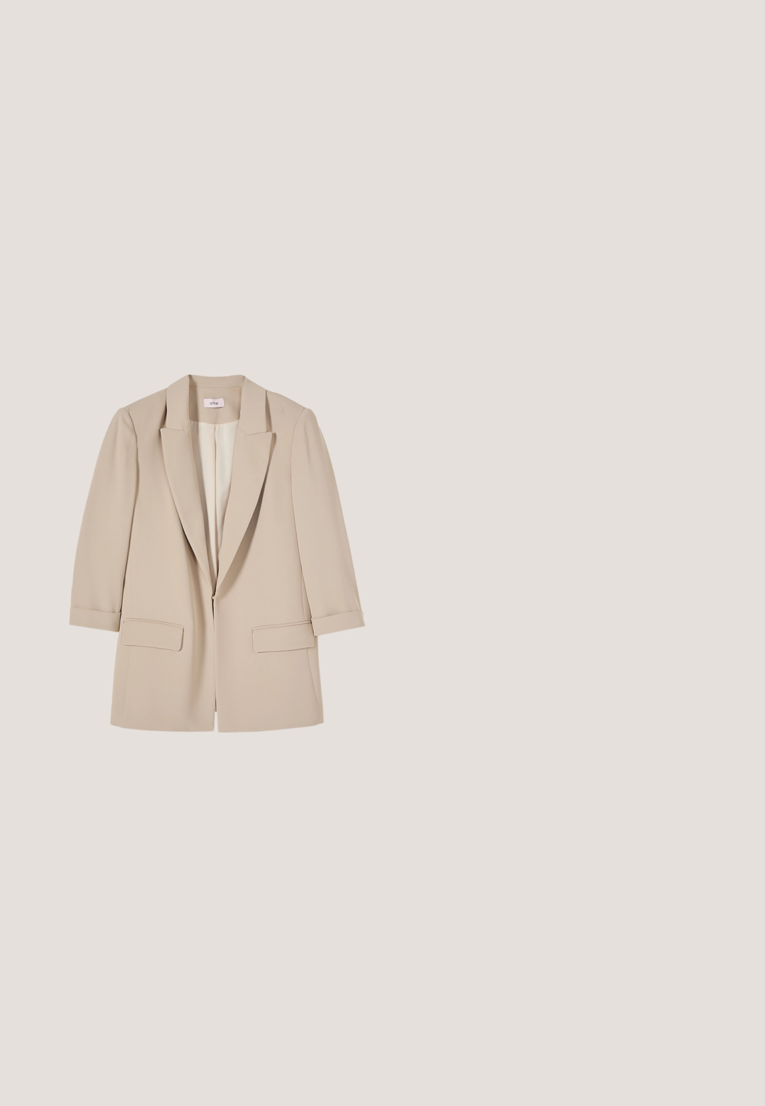 Blazer beige de mujer con solapas con muesca, dos bolsillos delanteros con solapa y mangas de largo tres cuartos, mostrado sobre un fondo blanco.; Blusa blanca de manga larga con un profundo escote en V, material suave similar al satén y puños de manga fruncidos para un ajuste relajado.; Pantalones plisados beige con un corte ajustado, hechos de una tela suave, que presentan una cinturilla clásica y un corte recto.; Mocasín marrón de cuero sin cordones con suela negra y tacón bajo, con detalle de correa en la parte superior.; Bolso tote de cuero beige claro con dos asas. Presenta un logo "RL" en relieve en la parte frontal, una superficie texturizada y un diseño de abertura en la parte superior.; Reloj rectangular dorado con esfera blanca, agujas y marcadores dorados, con la marca "Skagen Denmark", combinado con una correa de cuero marrón.