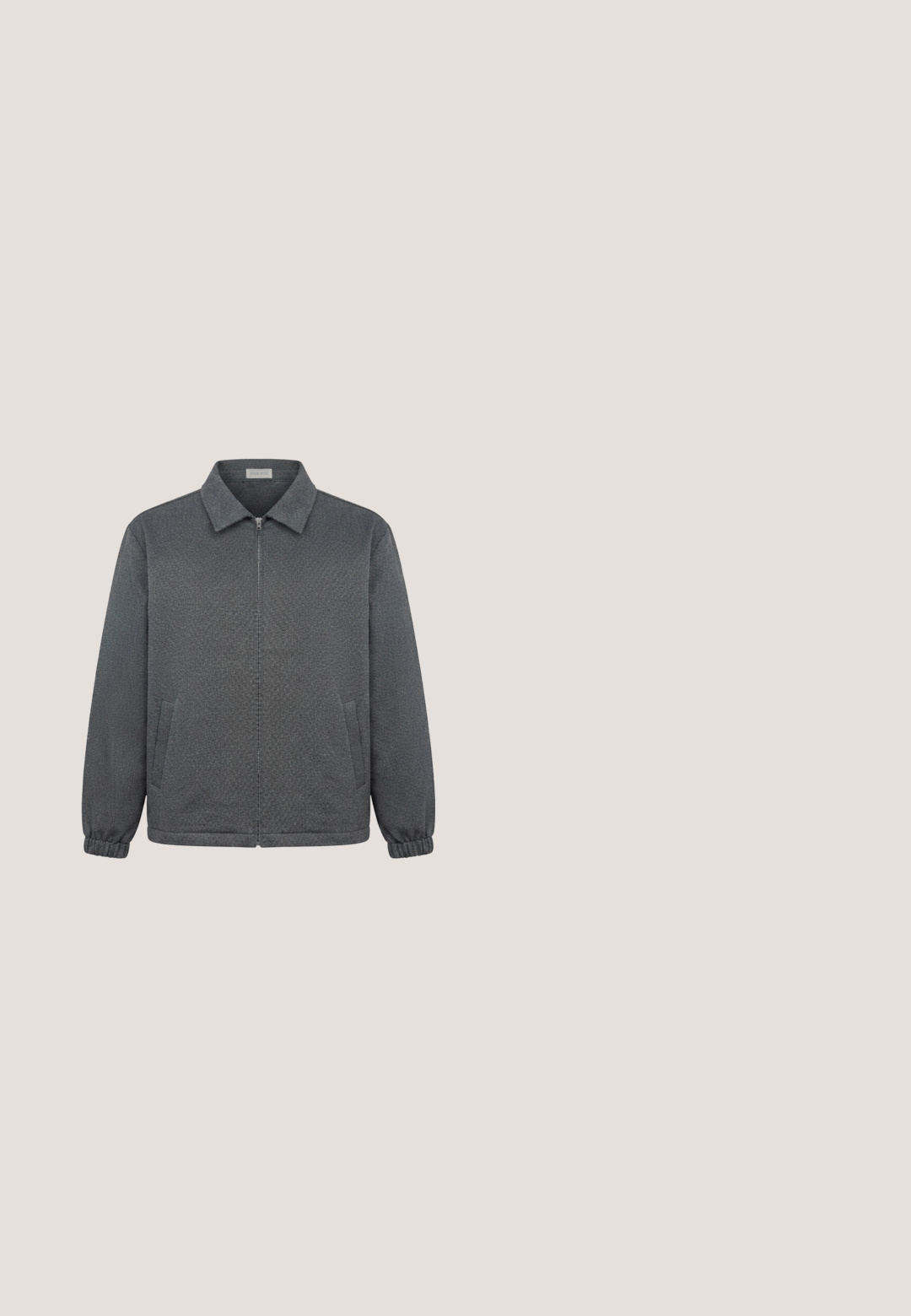 Chaqueta de cremallera gris oscuro con cuello, puños elásticos y dos bolsillos delanteros, mostrada sobre un fondo blanco.; Polo gris confeccionado en una mezcla de algodón, con cuello, tapeta de tres botones y mangas cortas; textura suave con un ligero brillo.; Pantalones cortos negros hasta la rodilla con trabillas para cinturón, cierre con botón y cordón ajustable en la cintura.; Bota de cuero negra hasta el tobillo con punta redonda, collar texturizado, cordones planos, suela de goma y detalle de etiqueta naranja. Acentos cosidos a lo largo del borde.; Gafas de sol rectangulares con montura transparente clara y lentes tintadas degradadas en azul, descansando sobre una superficie blanca.; Bolso bandolera de cuero azul marino con acabado texturizado, forma rectangular, cierre superior con cremallera, correa negra ajustable y herrajes de tono plateado.