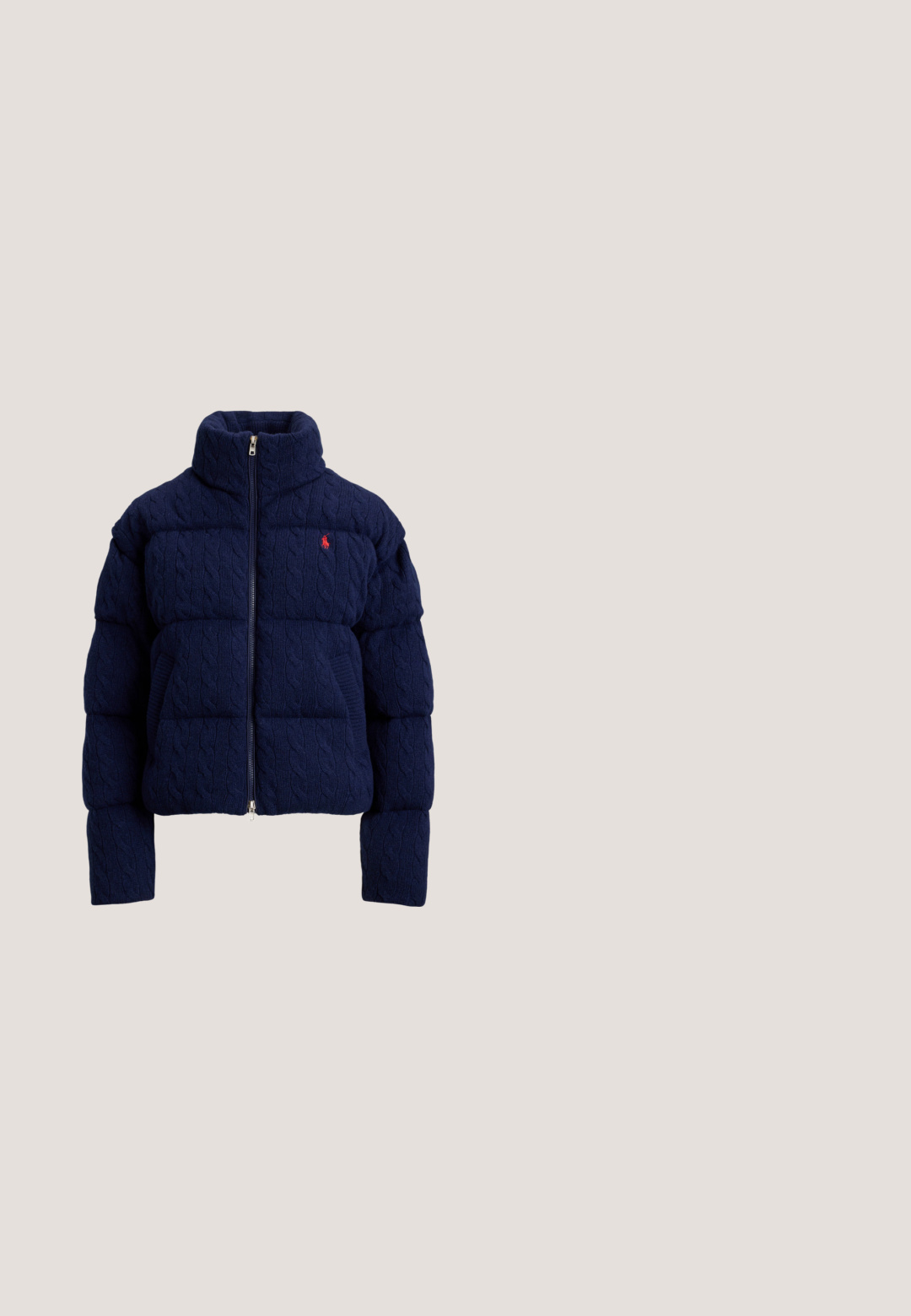 Marineblaue gesteppte Daunenjacke mit Zopfmuster-Struktur, hohem Kragen, Frontreißverschluss und kleinem roten besticktem Logo auf der Brust.; Marineblauer Strickpullover mit einem strukturierten Motiv der amerikanischen Flagge in Rot, Weiß und Blau. Gerippte Bündchen und Saum, mit "RL"-Logo nahe dem Saum.; Dunkelblaues Jeanshemd mit langen Ärmeln, Knopfleiste vorne und zwei Pattentaschen mit Knöpfen auf der Brust, präsentiert vor einfarbig hellem Hintergrund.; Jeans mit hoher Taille und weitem Bein in mittlerem Blau. Verfügt über aufgesetzte Vordertaschen und auffällige Nähte. Glatte, weiche Textur.; Weiße Sneakers aus synthetischem Material, mit einem metallisch goldenen Streifen und einem Akzent an der Ferse, ausgestattet mit einer strukturierten Gummisohle.; Dunkelgrüne Wildleder-Schultertasche mit geschwungener Form, goldfarbenen Beschlägen und kurzem Riemen mit Verschlussdetails.
