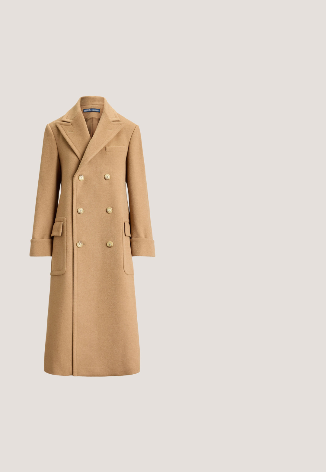 Lange dubbelgeknoopte wollen mantel in kameelkleur met brede revers, zes knopen, klepzakken en omslagmouwen.; Beige kabelgebreide trui met lange mouwen en geribbelde boorden, met een klein geborduurd Polo Ralph Lauren-logo op de borst.; Beige blouse met lange mouwen, verticale bruine en oranje strepen, knoopsluiting aan de voorkant en een gebonden strik bij de hals.; Bruine broek met hoge taille en wijde pijpen, met riemlussen, een knoop aan de voorkant en ritssluiting tegen een lichte achtergrond.; Bruine suède ballerina met een ronde neus, voorzien van een geknoopte detail aan de voorkant, dunne rode bies en een platte zwarte zool.; Bruine suède en lederen handtas in halve maanvorm met enkele band en goudkleurige sluiting met een klein paard en ruiter logo.