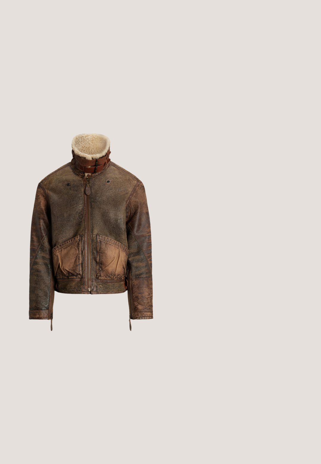 Chaqueta de cuero marrón desgastada con cuello de borreguillo, cremallera frontal, correas con hebilla, dos bolsillos frontales y puños con cremallera.; Suéter burdeos de punto trenzado con media cremallera, cuello, puños y bajo acanalados, con un pequeño logo verde de Polo en el pecho.; Camisa de cuadros de manga larga en rojo, azul y verde con cuello abotonado, bolsillo en el pecho y bordado del logo en el lado izquierdo.; Pantalones de pana marrones con bolsillos frontales, trabillas para cinturón y cierre de botones, mostrados sobre un fondo blanco.; Bota de ante marrón hasta el tobillo con cordones en el frente, detalles de costura, lazo para tirar en el talón y suela blanca con relieve sobre fondo liso.; Cinturón de cuero negro con hebilla rectangular de plata estampada con un jugador de polo montado a caballo sosteniendo un mástil.