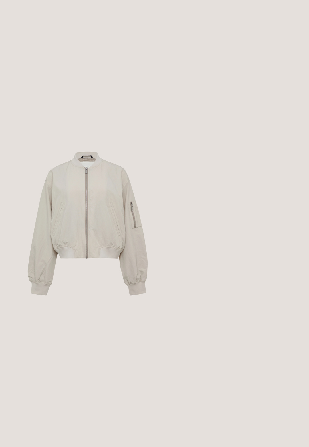 Geknipte bomberjack in lichtbeige stof, met een ritssluiting aan de voorkant, geribbelde manchetten en twee zijzakken met een extra ritszak op de mouw.; Witte korte mouwen t-shirt gemaakt van zachte stof met het "Marc O'Polo" logo in vervaagd zwart drukwerk op de voorkant. Ronde halslijn.; Lichtblauwe high-waist spijkerbroek met rechte pijpen, voorzakken, riemlussen en zichtbare knoop- en ritssluiting.; Bruine leren loafer met een stevige donkerbruine profielzool en een leren bandje met een klein zwart logodetail op de wreef.; Beige draagtas met bruine leren handvatten en een klep aan de voorkant met drukknop, eenvoudig ontwerp, rechthoekige vorm met licht taps toelopende zijkanten.; Zilveren ketting met een dun ontwerp, voorzien van een kleine ronde hanger met een donkere kern en een delicate sluiting aan de achterkant.