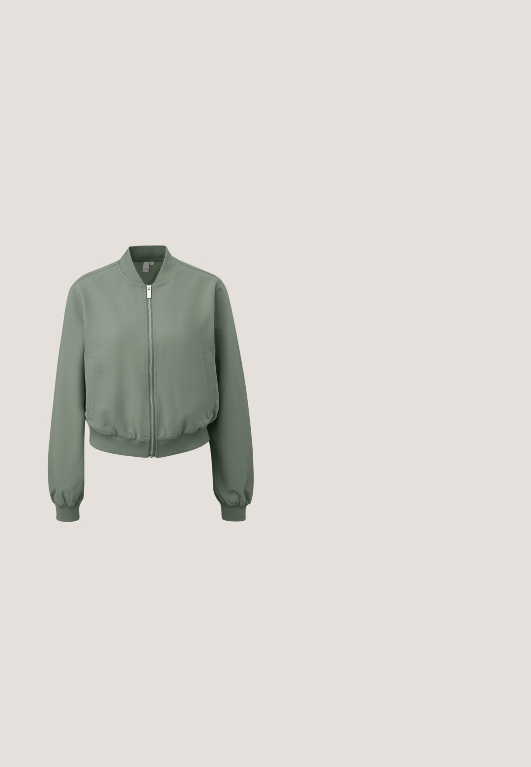 Lichtgroene bomberjack met voorrits, geribde manchetten, tailleband en twee voorzakken, getoond op een witte achtergrond.; Lichtgroen oversized sweatshirt met een ronde hals, raglanmouwen en een zachte textuur. Heeft een geribbelde hals en zoom.; Lichtgrijze wijde broek met elastische tailleband, trekkoord en zijzakken, afgebeeld op een witte achtergrond.; Lichtgroene suède sneaker met perforaties, witte veters en een rubberen zool in kleur van kauwgom. Ronde vorm, lage stijl en zachte textuur.; Lichtgroene gewatteerde shopper met gevoerde handvatten en een klein wit logovlekje centraal geplaatst vlak bij de bovenkant tegen een effen achtergrond.; Zilveren sieradenset met een ketting, armband en oorbellen. Hartvormige versieringen met gedetailleerd vakwerk en een "Guess" bedel.