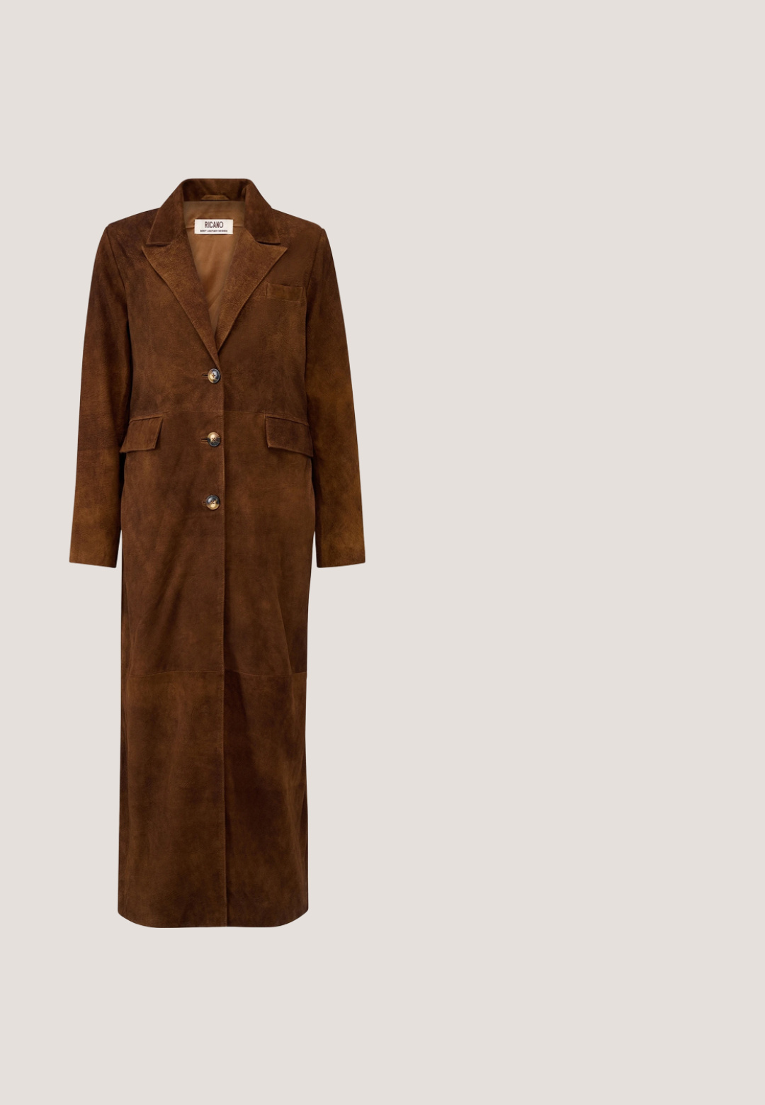 Bruine lange suède jas met drie knopen, twee klepzakken en een getande reverskraag.; Bruine mouwloze jumpsuit met kraag, borstzakken, wijde pijpen en een bijpassende riem met ronde gesp.; Bruine suede cowboylaars met een puntige neus, decoratieve stiksels, enkellengte en een gestapelde hak. Voorzien van een lusje voor eenvoudig aantrekken.;  schildpadzonnebril heeft ovale lenzen met een bruine tint. Gouden accenten zijn aanwezig op de armen, die gedetailleerd beslag benadrukken.; Donkerbruine crossbodytas met krokodillenstructuur, brede bruine band en goudkleurige hardware, met het Kurt Geiger London-logo aan de voorkant.; Verstelbare bruine koordarmband met afwisselend kleine donkerbruine en gouden kralen en een kleine gouden vogelbedel aan het uiteinde van één koord.