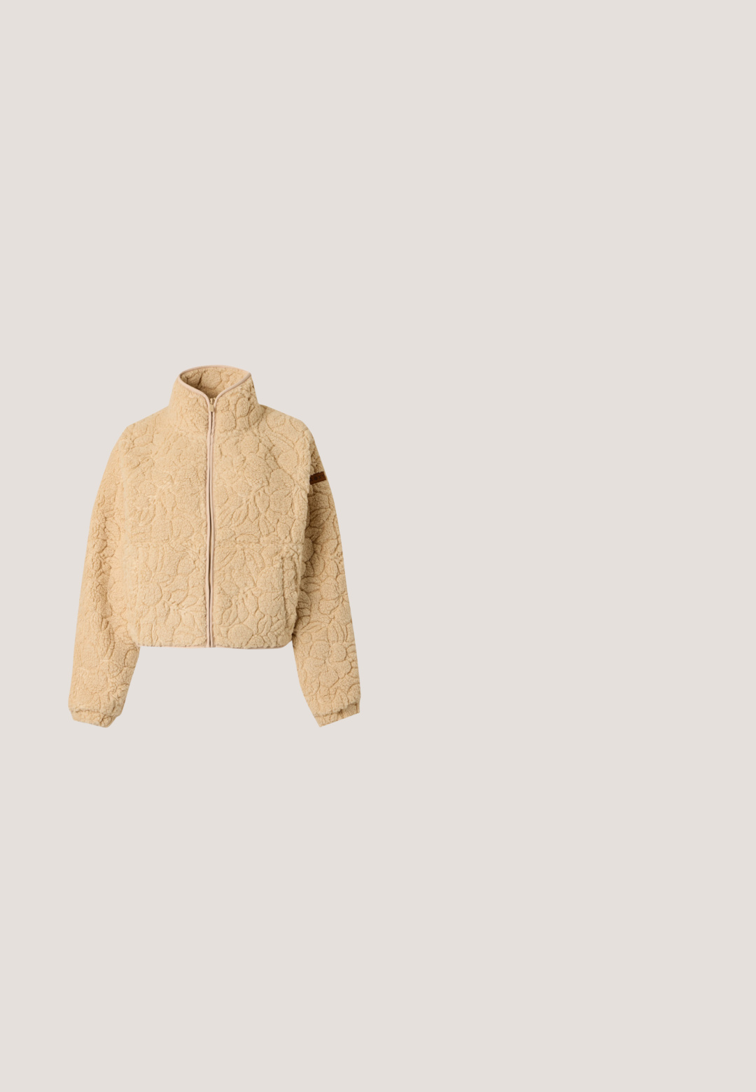 Μπεζ fleece μπουφάν με ολόκληρο φερμουάρ μπροστά, ψηλό γιακά, μακριά μανίκια και ανάγλυφο λουλουδάτο σχέδιο σε μαλακό ύφασμα.; Μπεζ φούτερ με πολύχρωμη τροπική σκηνή, το κείμενο «Rip Curl», φοίνικες, λουλούδια, ωκεανός και το σλόγκαν «Live the Search. Since 1969».; Ανοιχτό μπλε κοντομάνικο T-shirt με κοντά μανίκια και τσέπη στο στήθος, με γραφικό σχέδιο λευκού ήλιου και προσώπου και το κείμενο "VOLCOM".; Καφέ βερμούδα μέχρι το γόνατο με ελαστική μέση και κορδόνι, με μερικό λευκό και ροζ λουλουδάτο σχέδιο γραμμών στο δεξί πόδι.; Υψηλές αθλητικές μπότες από κίτρινο καμβά, με σχέδιο μικρών κόκκινων φράουλων, λευκές κορδόνες και λευκή σόλα με μαύρες ρίγες.; Ρόζ και λευκή τσάντα tote με μακριές λαβές και μικρό μεταλλικό λογότυπο Puma στο μπροστινό μέρος, σε απλό φόντο.