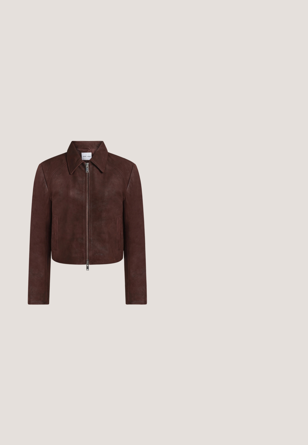 Veste en cuir marron avec fermeture éclair à l'avant, col pointu, manches longues et deux poches latérales, présentée sur un fond blanc uni.; Top sans manches marron avec un ourlet asymétrique et un fermoir décoratif en or sur le côté.; Pantalon marron à jambes larges avec une texture lisse, doté d'une fermeture à boutons, de poches avant et d'une coupe ajustée sans motifs visibles.; Escarpin en daim marron à talon haut et bout pointu avec un talon aiguille étroit et élégant sur un fond clair uni.; Sac hobo en daim marron avec une grande ouverture courbée et une large bandoulière. Présente une couture centrée à l'avant. Texture lisse.; Collier doré avec trois pendentifs irréguliers en forme de galets lisses sur une chaîne fine avec fermoir réglable.