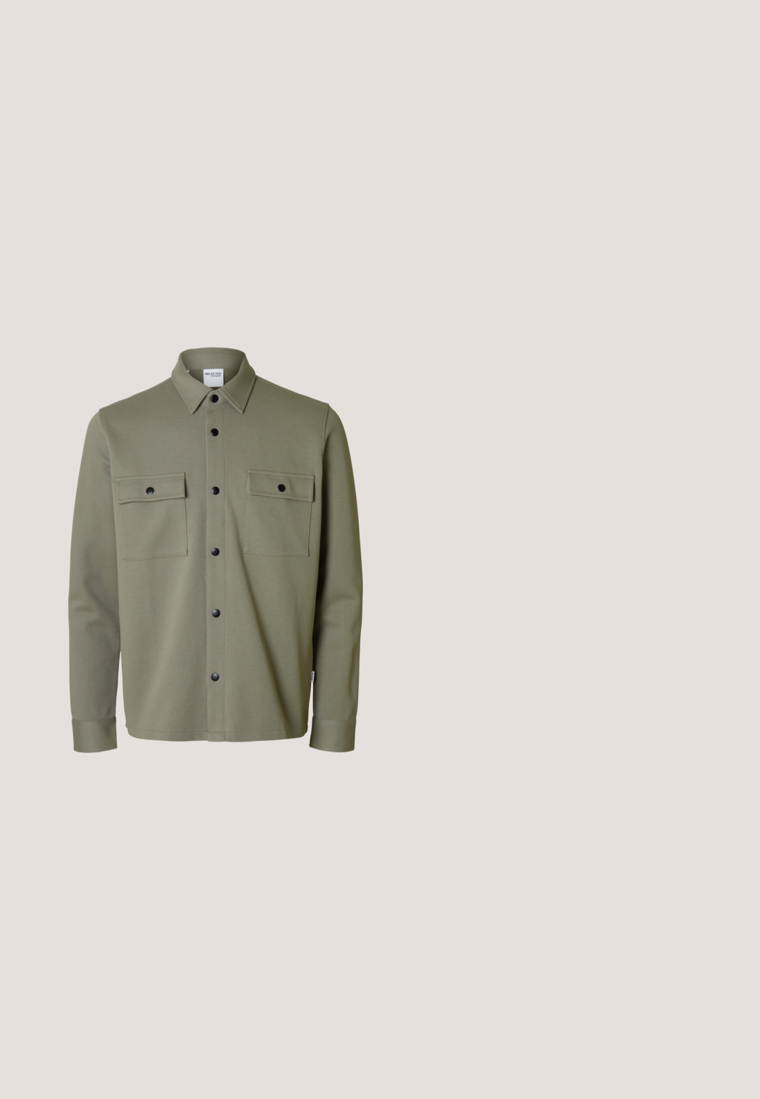 Veste-chemise kaki à manches longues avec col, boutons-pression noirs sur le devant et deux poches poitrine avec rabats à boutons.; Chemise noire à manches longues avec un col rond, patte de boutonnage à trois boutons et poignets ajustés. Fabriquée en tissu doux avec une texture lisse.; Pantalons cargo gris en mélange de coton, dotés d'une taille élastique, de poches latérales et d'une conception de jambe fuselée avec des coutures en panneaux.; Bottine en cuir brun foncé avec des lacets verts, une semelle texturée et une petite étiquette en tissu tan près du col, sur fond blanc.; Sac à dos en cuir marron avec rabat et fermeture à boucle, poche avant avec boucle, et poignée supérieure sur fond blanc.; Ceinture camouflage noire et marron en tissu durable, dotée d'une boucle en plastique noir mat et d'un design ajustable pour un ajustement sécurisé.