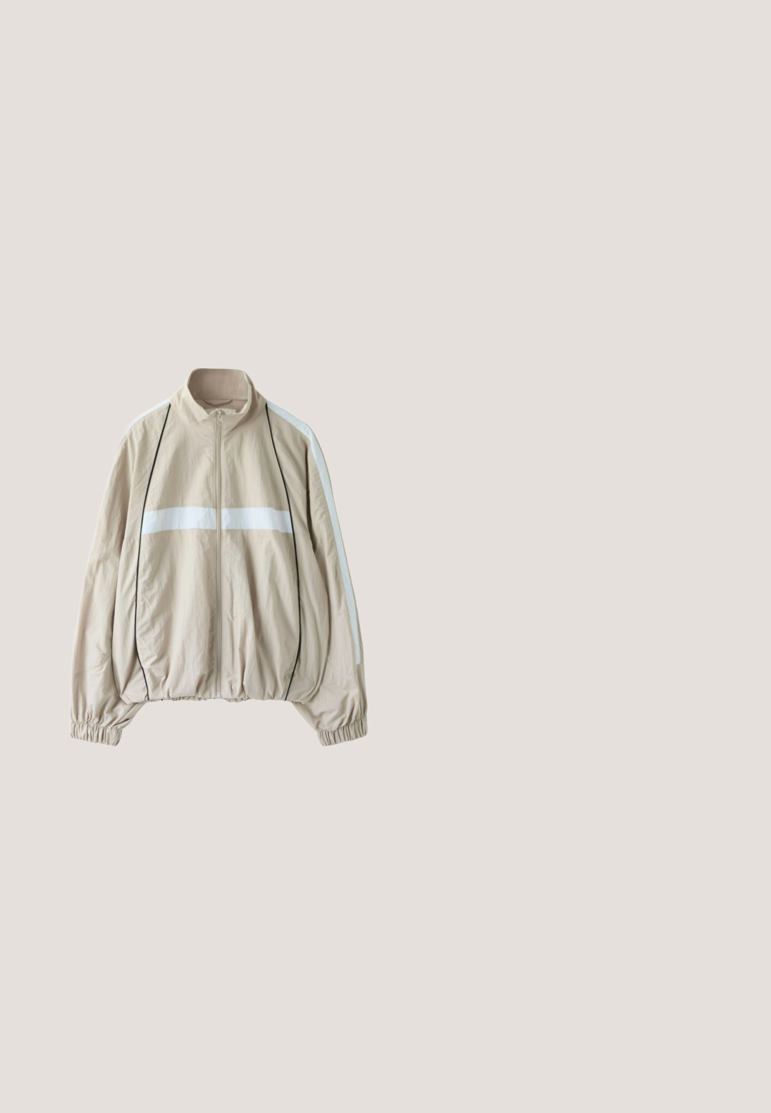 Veste beige zippée avec bande horizontale blanche sur la poitrine, bandes blanches aux manches, passepoil noir, poignets élastiques et ourlet froncé.; Body gris sans manches avec doublure intérieure blanche, encolure arrondie et jambes courtes.; Sweatshirt gris court avec de longues manches ballon, un col montant et une fermeture à glissière quart avec un détail de fermeture éclair en argent.; Chaussure beige Puma Mary Jane avec une bride sur le dessus et une semelle grise recouverte de picots ronds en caoutchouc.; Lunettes de soleil en forme de chat avec une monture argentée et des verres fumés, ornées de cristaux le long des bords et des tempes.; Sac fourre-tout gris clair avec deux poignées gris foncé et un subtil motif vertical noir sur le devant, photographié sur fond blanc.