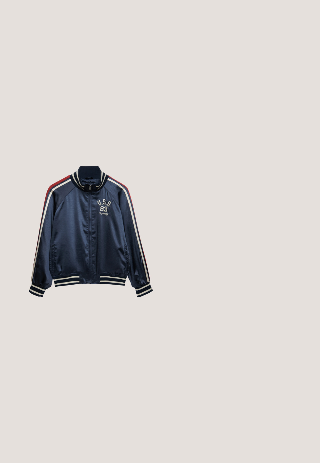 Marineblauw sportief jack met ritssluiting, witte en rode strepen op de mouwen, geribbelde kraag, manchetten en zoom, met "U.S.A 83 Superdry" geborduurd op de borst.; Marineblauw T-shirt met korte mouwen, witte tekst "Custom Superdry Montauk LI." en een kreeftafbeelding op de voorkant.; Navyblauwe shorts van zacht materiaal met een elastische tailleband, een trekkoord, zijzakken en een klein wit SuperDry-logo.; Zwarte rubberen regenlaars met een ronde neus, textuurzool en verstelbaar riempje. Gladde oppervlakte met een matte afwerking.; Blauwe zonnebril met gradient lenzen, een matte afwerking en dunne metalen armen. Accentueert met doorzichtige plastic punten voor comfort.; Marineblauwe tote tas met lange hengsels, met witte tekst ""Superdry & Co Authentic Premium Outfitters"" en een lauwerkrans logo.