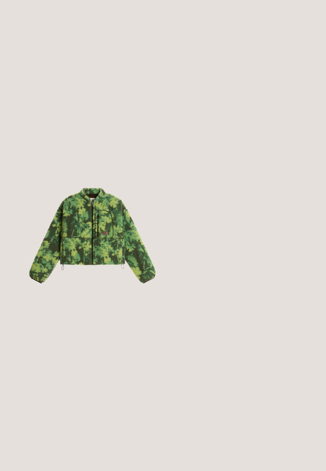 Grüne und dunkelgrüne, camouflagegemusterte Fleecejacke mit durchgehendem Reißverschluss, langen Ärmeln und einer Reißverschlusstasche auf der linken Brustseite.; Olivgrüne Corduroy-Overalls mit weitem Bein, verstellbaren Trägern und einer strukturierten Oberfläche. Einfaches Design, keine sichtbaren Muster oder Beschläge.; Grüner Schlupfschuh mit dicker schwarzer Sohle, die ausgehöhlte Bereiche aufweist, glattem Obermaterial und kleinem ovalem Ausschnitt nahe der Ferse.; Swarovski Sonnenbrille - transparent green; Hellgrüne, gesteppte Tragetasche mit gepolsterten Griffen und kleinem weißen Logoaufnäher, der nahe der Oberseite zentriert ist, vor einfarbigem Hintergrund.; Schwarzes Stoff-Scrunchie mit hellgrün genähten Kanten auf hellem einfarbigem Hintergrund.