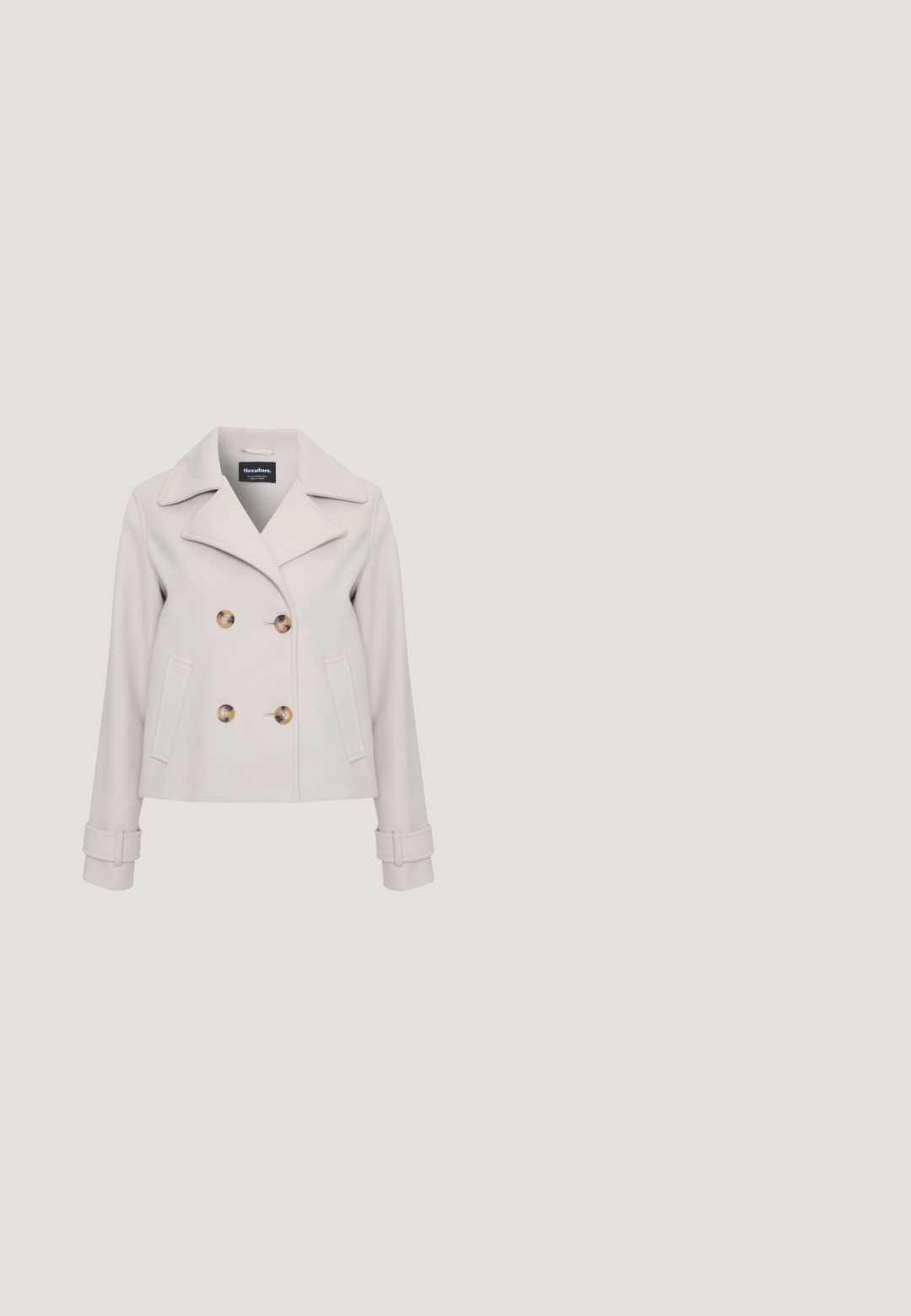 Manteau en peau gris clair avec de grands boutons marron, col à pointe, design à double boutonnage et poches latérales. Présente des détails au niveau des poignets.; Pull en maille crème à manches courtes, col rond et étiquette de la marque Saint au col.; Pantalon large beige à taille haute avec une fermeture frontale cachée, présenté sur un fond blanc.; Baskets basses en daim beige avec lacets blancs, détails perforés sur les côtés et semelle en caoutchouc marron clair, présentées de profil.; Sac à main en cuir crème avec bord supérieur incurvé, une bandoulière unique et fermeture à rabat dorée à l’avant.; Paire de boucles d'oreilles clous en forme de goutte irrégulière ton or poli sur fond blanc.