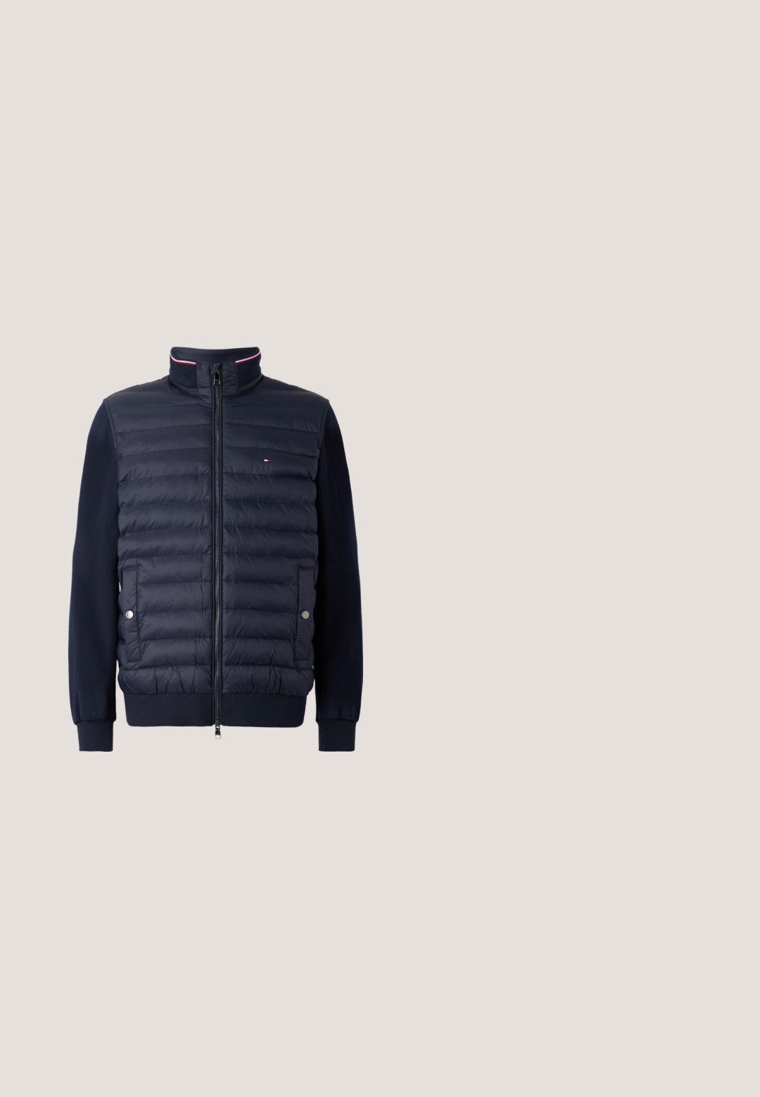 Sort quiltet jakke med lange ærmer, lynlås foran, to lommer med trykknapper og lille rød, hvid og blå logo på brystet.; Lyseblå langærmet pullover med en halv lynlås og et lille broderet Tommy Hilfiger-logo på venstre bryst.; Lyseblå T-shirt med korte ærmer og V-hals med lille rød, hvid og blå logo på venstre bryst mod en hvid baggrund.; Lyseblå bomulds-chinos i slim fit med knaplukning, bælteløkker og sidelommer, glat tekstur og lige ben.; Brun læderloafer med kvaster, der svæver over et tekstureret beige tæppe med et rundt træbord og stablede bøger i baggrunden.; Sort vævet stofbælte med sølvfarvet metalspænde indgraveret med "Levi's" og sorte læderdetaljer på hvid baggrund.