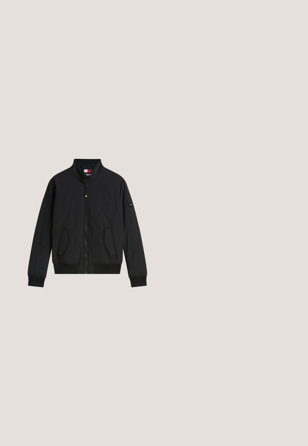 Sort quiltet jakke med lynlås foran, ståkrave, to skrå lommer og lille logo-patch på venstre ærme.; Grå strikket sweater med et centralt logo med "TOMMY" og "JEANS" i hvid og marineblå, med en rød og hvid stribet rektangulær accent.; Rød langærmet skjorte lavet af bomuld. Har en rund halsudskæring og et lille logo på venstre bryst. Glat tekstur med ensfarvet design.; Sorte slim-fit jeans i denim materiale med en glat overflade. Med fem lommer og en lynlås med knaplukning i taljen.; Sort ruskind snørebånd ankelstøvle med trækflig og lav stablet hæl, set fra siden på hvid baggrund.; Sort duffeltaske med tekstureret overflade, dobbelte håndtag, justerbar skulderrem og en frontlynlås med rødt accent.