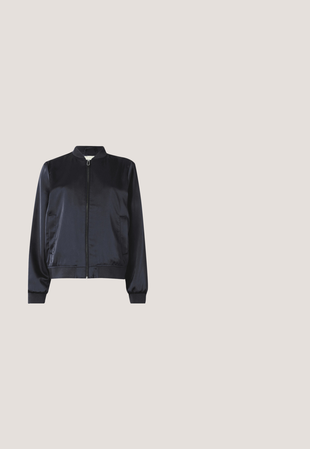Marineblå satin bomberjakke med lynlåslukning, ribbede ærmer og kant samt to sidelommer. Glat tekstur og struktureret design.; Marineblå bluse med korte ærmer med opkrogede manchetter, V-udskæring og kort guldlynlås foran i midten.; Marineblå shorts lavet af blødt stof med flad foran, to sidelommer og et subtilt plisseringsdesign. Har et mærke ved taljen.; Sort spids flad sko med dekorative remme svævende over en træbænk udendørs med grønne planter i baggrunden.; Stor navy blå mulepose med lange håndtag ved siden af en matchende navy blå lynlåspung med kvastdetalje.; Par sølv øreringe med chunky kædelinkdesign og sorte stifter på en ensfarvet lys baggrund.