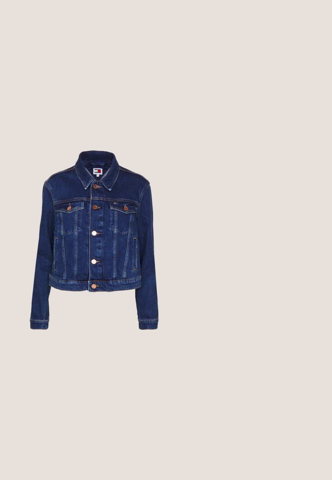 Veste en denim bleu foncé avec un col, fermeture à boutons sur le devant, deux poches poitrine et une coupe courte, dotée de quincaillerie en ton cuivre et de coutures.; T-shirt noir à manches courtes avec col rond, coupe ample, en tissu doux, présenté sur un fond blanc.; Jupe en coton noir avec un design plissé, une fermeture à bouton et des passants de ceinture. Longueur courte avec une texture lisse et sans motifs visibles.; Mules noirs en cuir à enfiler avec un bout pointu, un design minimal et un accent texturé au talon arrière. Surface lisse et semelle plate.; Sac bandoulière en cuir noir avec fermeture à rabat, ferrures dorées et bandoulière amovible. Présente des détails de coutures apparentes.; Des boucles d'oreilles en or en forme de créole avec un design texturé, présentant un gemme transparent rond suspendu à la base, accentué par de plus petites pierres claires le long de la créole.
