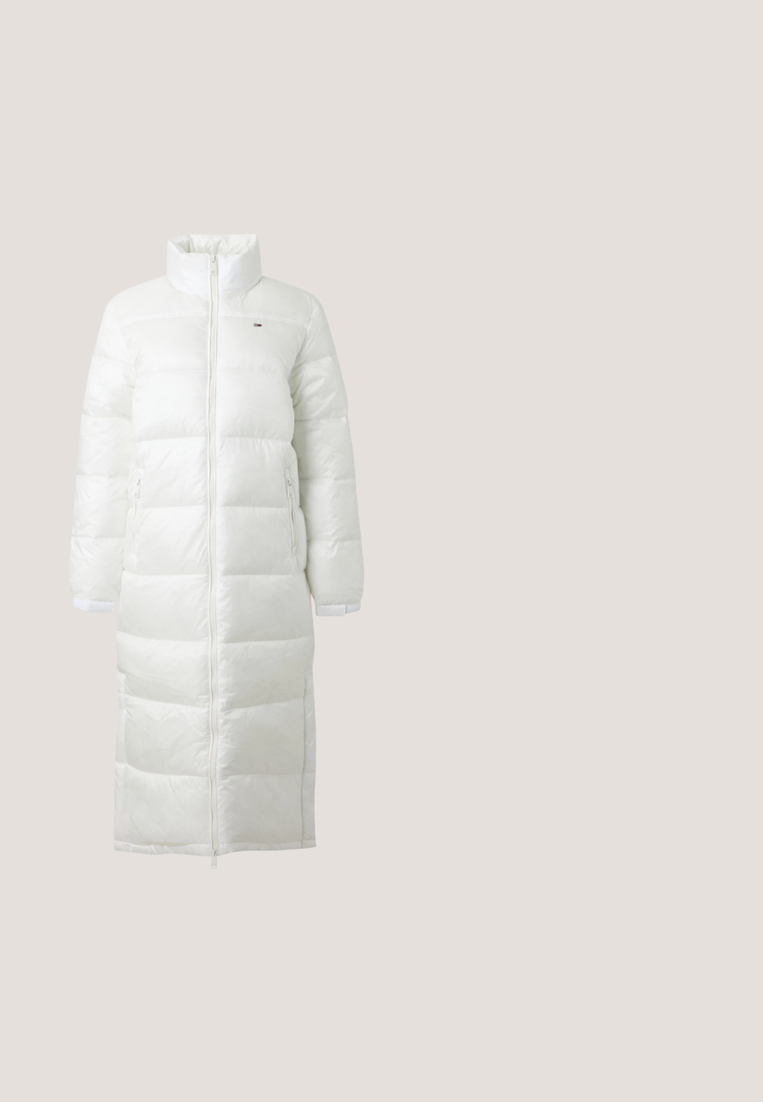 Lang hvid dynejakke med høj krave, fuld lynlås foran, to lynlåslommer i siderne og lange ærmer.; Lyserød langærmet sweatshirt med høj krave og lynlås samt et lille grønt krokodillelogo på venstre bryst.; Lyserød ribbet T-shirt med korte ærmer, rund halsudskæring og et lille grønt Lacoste-krokodillelogo på venstre bryst.; Lyserøde sweatpants med elastisk talje, tapede ben og sammenfoldede elastiske manchetter ved anklerne, på en ensfarvet baggrund.; Løbesko med pink, beige og cremet mesh samt syntetiske overlays, kraftig sål og tekstureret ydersål for greb, set fra siden.; Beige mulepose med lange stropper og en lille aftagelig grøn lynlåslomme fastgjort til den ene strop, vist på en ensfarvet baggrund.