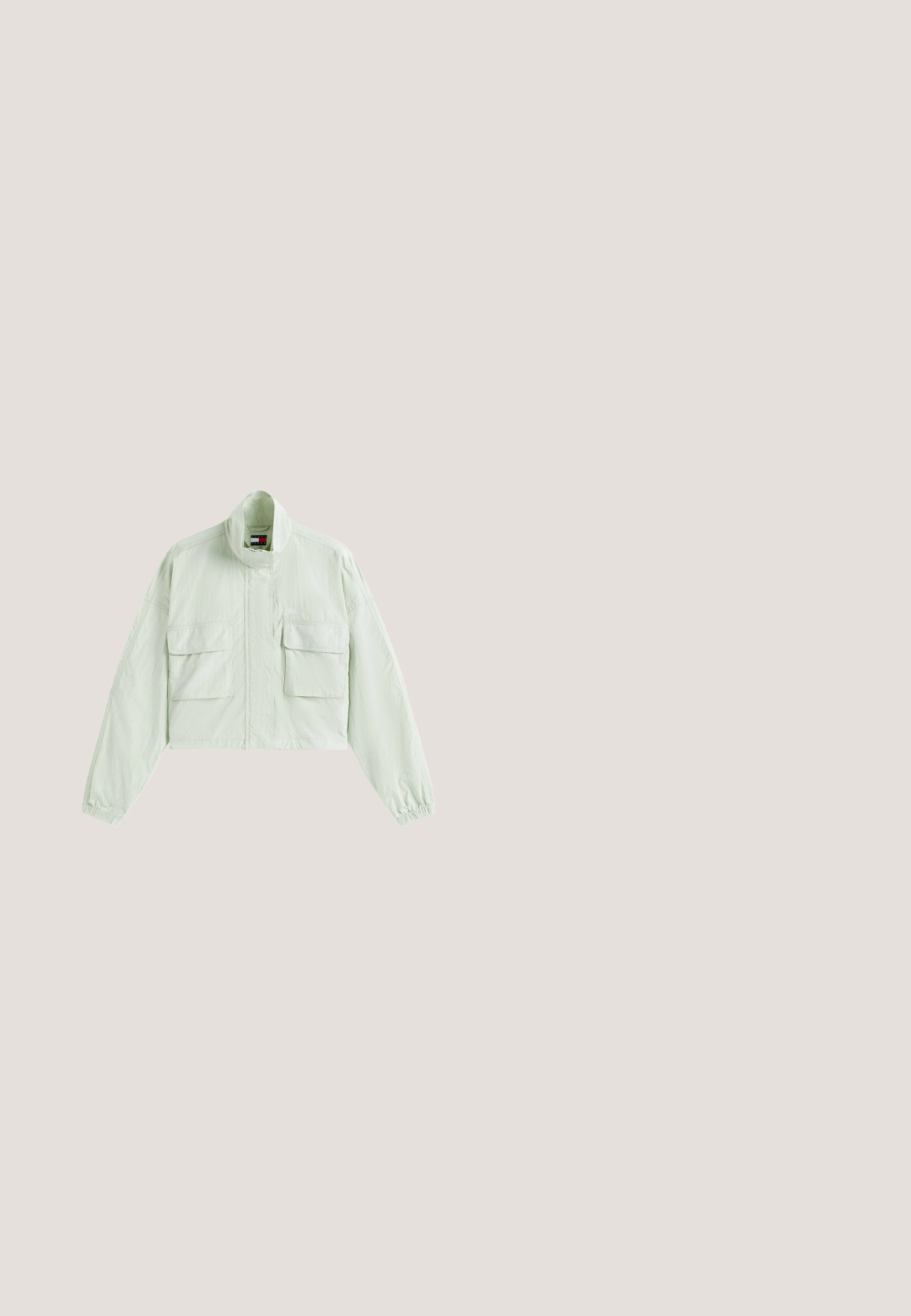 Hellgrüne kurze Jacke mit hohem Kragen, langen Ärmeln mit elastischen Bündchen und zwei großen vorderen Klappentaschen.; Hellgrünes Poloshirt mit kurzen Ärmeln, Knopfleiste und kleinem Tommy Hilfiger Logo auf der linken Brustseite.; Hellegrüne ausgestellte Denim-Jeans mit Knopfverschluss und fünf Taschen. Mit einem rohen Saum am unteren Ende und glattem, leicht strukturiertem Stoff.; Niedriger Sneaker in Creme und Hellgrün mit Schnürverschluss, weißer Sohle und kleinem goldenen Logo auf dem Seitenpaneel.; Rosa Ledertasche mit rechteckiger Form, zwei Griffen und einem kleinen Metallemblem auf der Vorderseite, mit einer glatten, glänzenden Oberfläche.; Ohrringe aus Sterlingsilber mit einem gedrehten Design, das glatte und glänzende Oberflächen aufweist. Keine sichtbaren Muster oder Akzente.