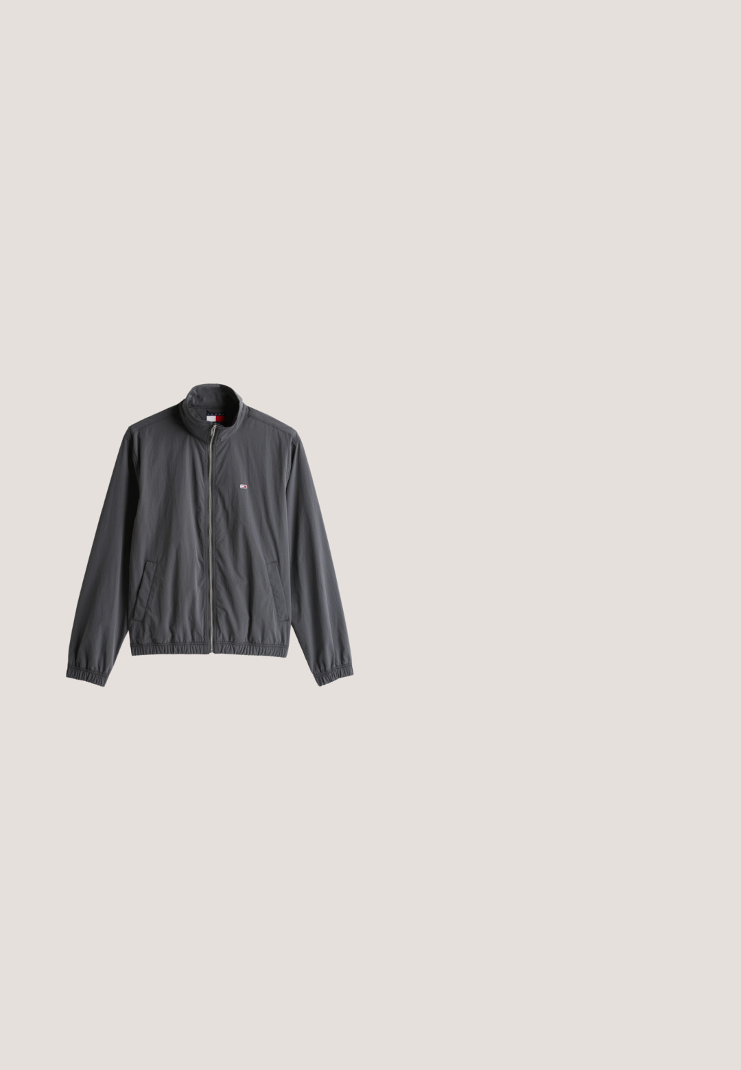 Grå, letvægts zip-up jakke med ståkrave, sidelommer, elastiske manchetter og et lille logo på brystet. Glat tekstur, afslappet design.; Sort bomulds t-shirt med rund hals. Har hvidt trykt tekst, der læser "Raffinato Sport" og "ellesse" med vintage detaljer.; Mørkegrå denimshorts med normal pasform, der har fem lommer, knaplukning og en struktureret talje. Blød tekstur, rent design.; Puma TARRENZ SB III - Sneakers high - black black shadow gray silver; Sølvmetalindfattede pilot-solbriller med blåtonede linser og sorte ender på stængerne, hvilende på en ensfarvet hvid overflade.; Sort stofpose med lynlås og et label-patch foran. Har en rektangulær form og et sidehåndtag for nem transport.