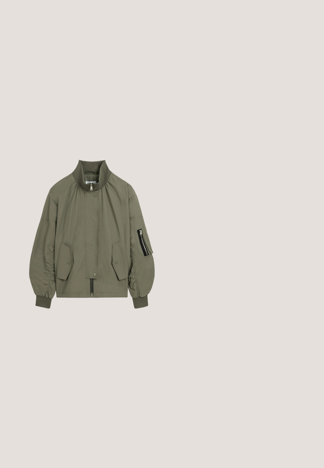 Olijfgroene bomberjack van lichtgewicht stof, met een hoge kraag, elastische manchetten, een ritssluitingen zijzak en een voorpaneel met drukknopen.; Zwarte cropped sweatshirt met een hoge kraag en een kwart rits. Heeft lange mouwen en een logo op de borst. Soepele stoftextuur.; Zwarte top met lange mouwen en een ronde hals, met witte geribbelde accenten bij de kraag en manchetten. Zachte textuur, casual pasvorm.; Marineblauwe leggings met een geribde zwarte tailleband. Ze hebben een gladde textuur en een aansluitend ontwerp met naaddetails langs de benen.; Zwarte suède enkelboots met een gestructureerde rubberen zool, een afgeronde neus, zichtbaar bont aan de bovenkant en een trekband aan de achterkant.; Zwarte leren heuptas met gouden studs aan de onderkant voorkant en een gouden ritstrekker aan de bovenkant.