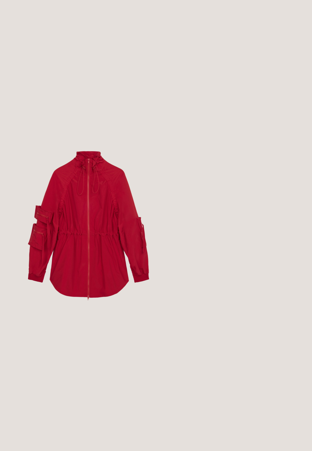 Veste coupe-vent rouge avec un col haut, fermeture éclair à l'avant, taille cintrée et plusieurs poches zippées sur les manches. Tissu lisse et léger.; Robe sans manches ajustée de couleur rose vif ornée de paillettes, avec un motif de palmier noir. Texture lisse, longueur courte et décolleté rond.; Chaussures en cuir vernissé rouge avec un bout carré, présentant un détail de nœud papillon et un petit talon bloc. Associées à un pantalon en velours noir.; Lunettes de soleil en plastique rouge de forme ovale, avec des verres dégradés marron et un logo doré sur les branches. Texture lisse avec une finition brillante.; Sac à main en cuir rouge en forme de gant de boxe avec l'inscription "Moschino Since 1983" en blanc et une bandoulière en chaîne argentée sur fond blanc.; Deux objets brillants en forme de cœur rouge placés côte à côte sur un fond blanc uni.