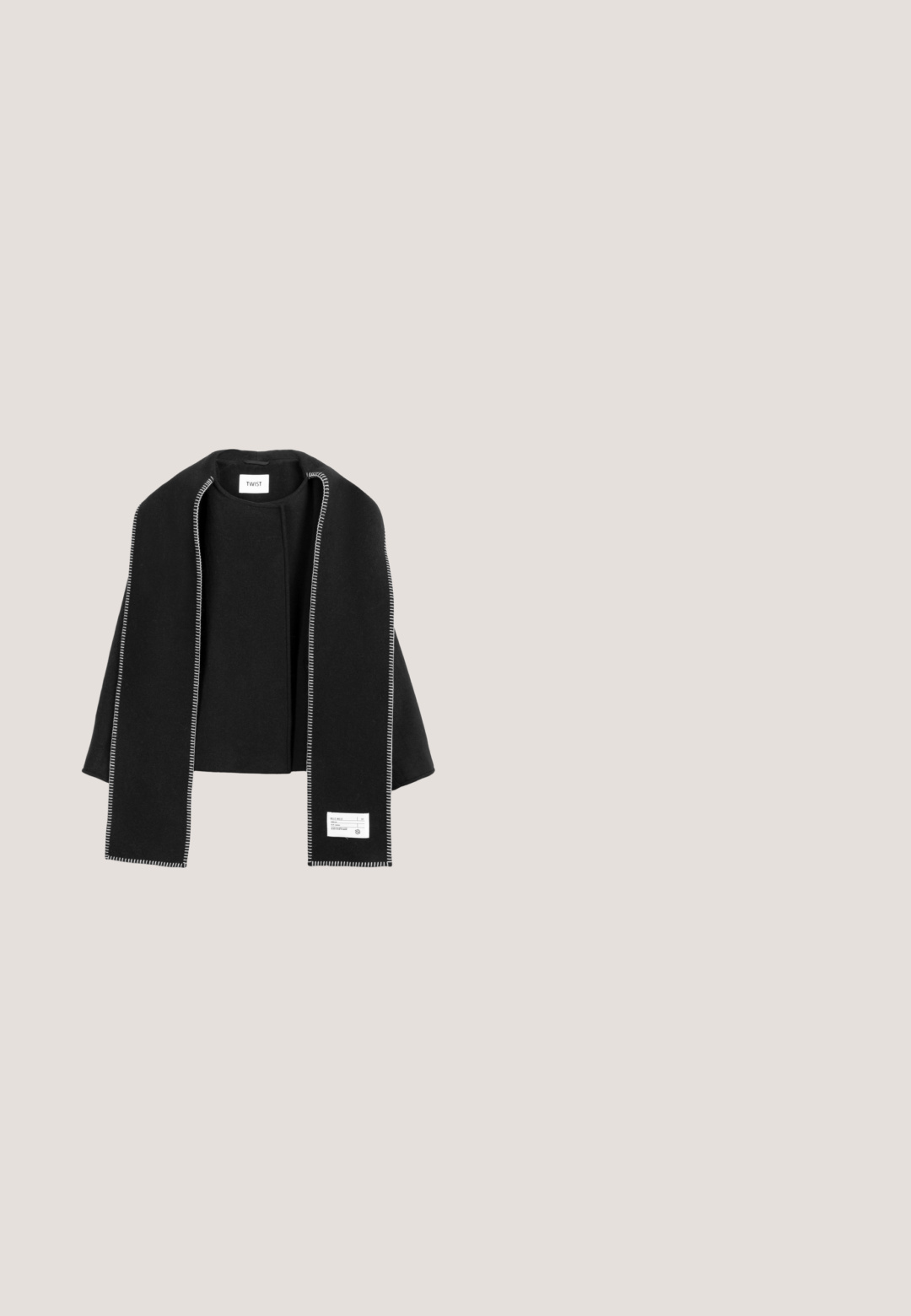 Zwarte wollen omslag met een open voorkant, voorzien van witte stiksels langs de randen en een stoffen label op de onderkant. Zachte textuur.; Zwarte trui met een ronde hals, voorzien van een sterrenpatroon in donkergroen. Zachte textuur, geribbelde boorden en onderrand voor een aangesloten look.; Donkergrijze rechte jeans met voorzakken, riemlussen, knoop en ritssluiting.; Zwarte enkellaars met dikke platformzool, krullende nepbont afgewerkt met een zilveren 'Karl' logo-detail op de boord.; Zwarte tote bag met witte nepbont rand en het "KARL LAGERFELD JEANS" logo in het wit aan de voorkant, voorzien van twee zwarte schouderhandvatten.; Zilveren oorbellen in de vorm van een hoofd met een zonnebril, versierd met heldere rhinestones voor detail en textuur, met een glanzend zwart accent.