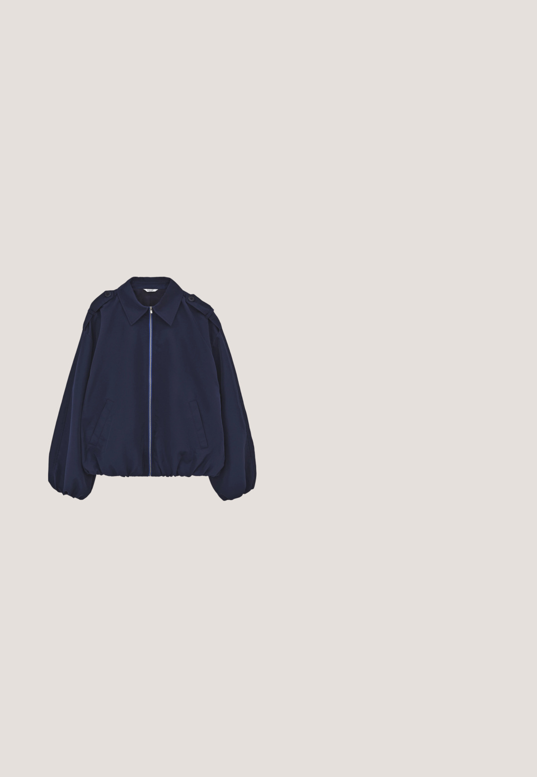 Marineblauw jack met lange mouwen, elastische manchetten en zoom, van achteren getoond op een witte achtergrond.; Marineblauwe sweatshirt met ribgebreide manchetten en halslijn, met witte fleece letters die "PARIJS" op de voorkant lezen.; Navyblauwe T-shirt met korte mouwen en ronde hals, voorzien van een klein geborduurd logo op de linkerborst en een wit merklabel aan de binnenkant van de kraag.; Donkerblauwe sweatpants met wijde pijpen, elastische tailleband en klein wit logo op de linker dij.; Blauwe suède sneakers met crèmekleurige nepbontaccenten, voorzien van drie witte strepen, vetersluiting en een gumrubberen buitenzool.; Marineblauwe stoffen draagtas met crèmekleurige banden, zachte textuur, nonchalant ontwerp en geperst logo. Ruime binnenkant met een casual stijl.