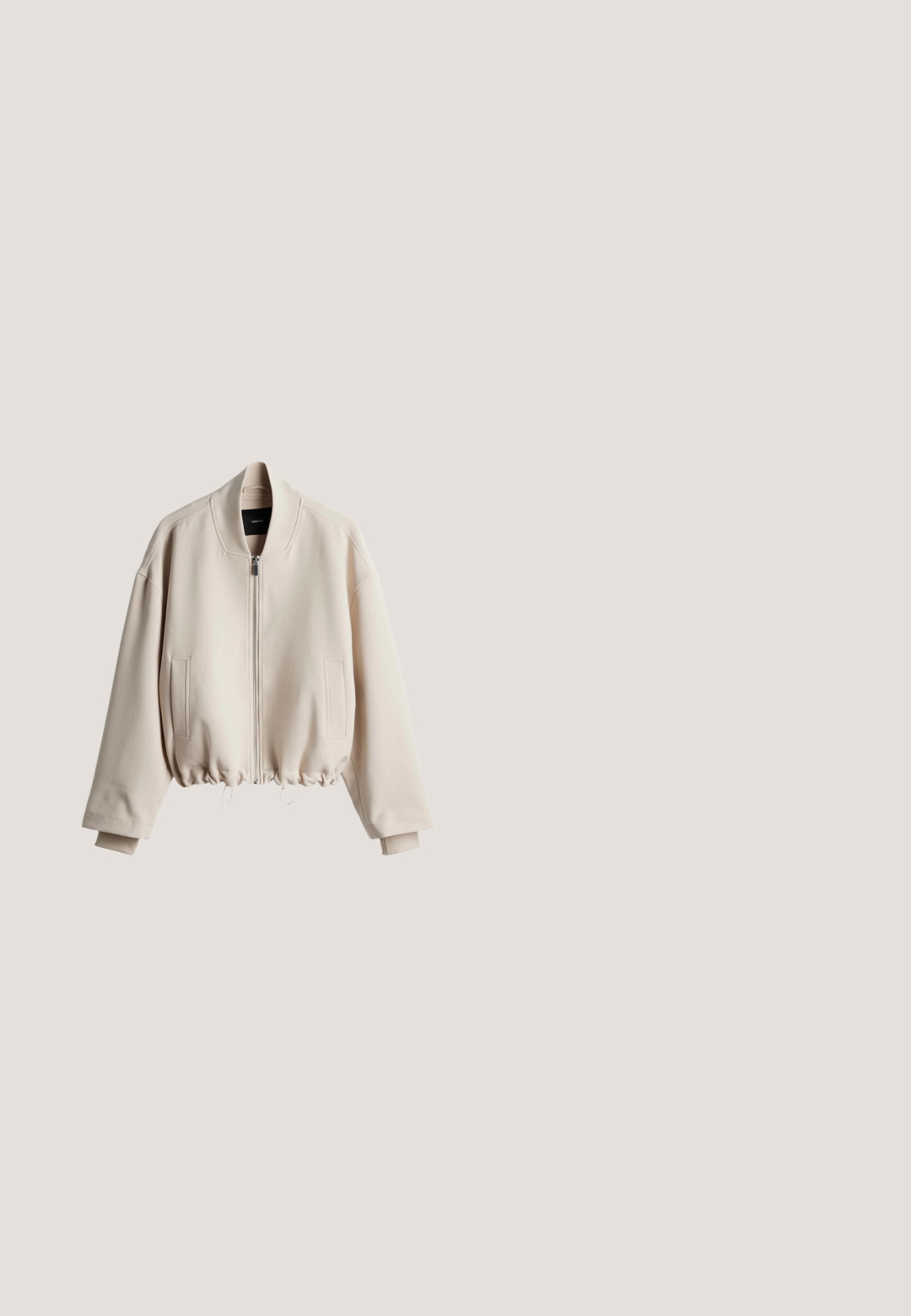 Beige Bomberjacke mit durchgehendem Reißverschluss, geripptem Kragen und Kordelzugsaum. Verfügt über Seitentaschen und eine glatte Textur.; Beige Strickjacke mit rundem Ausschnitt, fünf Knöpfen vorne und dreiviertellangen Ärmeln.; Beige T-Shirt mit kurzen Ärmeln aus weichem, strukturiertem Stoff. Verfügt über einen runden Ausschnitt und einen gerippten Saum, mit einer lässigen Passform.; Beige locker sitzende Hose mit elastischem Bund und Kordelzug, mit Seitentaschen und geraden Beinen.; Beiger Sneaker mit niedrigem Schaft, Schnürung vorne, glatten und Wildleder-Paneelen und flacher Gummisohle, von der Seite gezeigt.; Beige Leder Schultertasche mit einem breiten, verstellbaren Schulterriemen und einem Reißverschluss, vor einem weißen Hintergrund dargestellt.