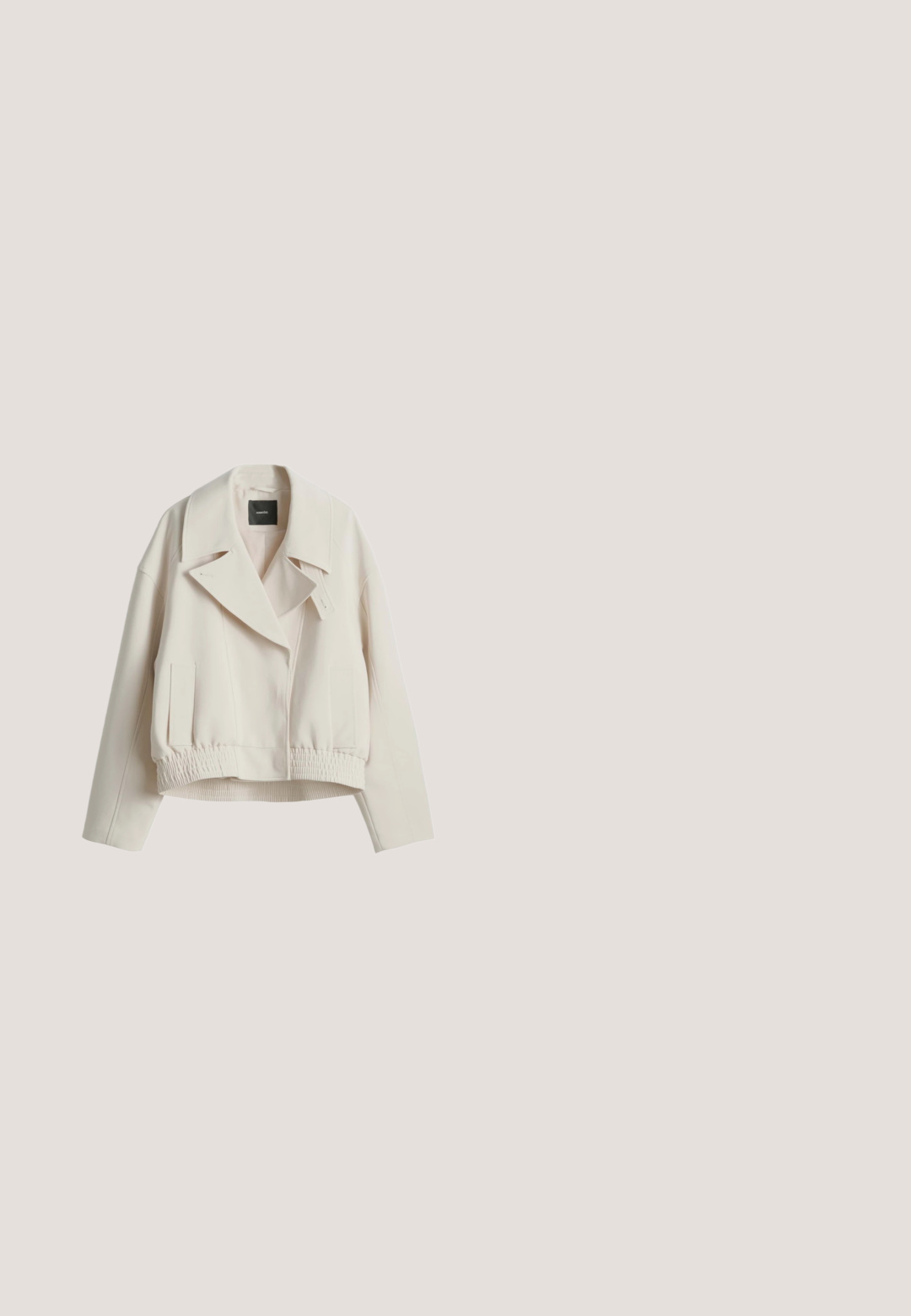 Lichtbeige cropped jas met brede revers, lange mouwen, elastische taille en voorste zijzakken, plat weergegeven op een witte achtergrond.; Korte mouwen, crème-kleurige gebreide poloshirt met een puntige kraag en een diepe V-hals. Gladde textuur en een ontspannen pasvorm, geen zichtbare hardware.; Beige katoenen broek met een recht model, voorzien van twee voorzakken en gestikte details langs de naden.; Beige suède penny loafer met mocassinnaad op de teen en rubberen profielzool, getoond vanaf de binnenkant op een witte achtergrond.; Taupekleurige leren tote bag met dubbele handvatten, gestructureerde zijkanten en een klein gouden "Lancaster Paris"-logo rechtsonder op de voorkant.; Zilveren ketting met een druppelvormige kristallen hanger. De ketting heeft een fijn linkdesign met een verstelbare sluiting.