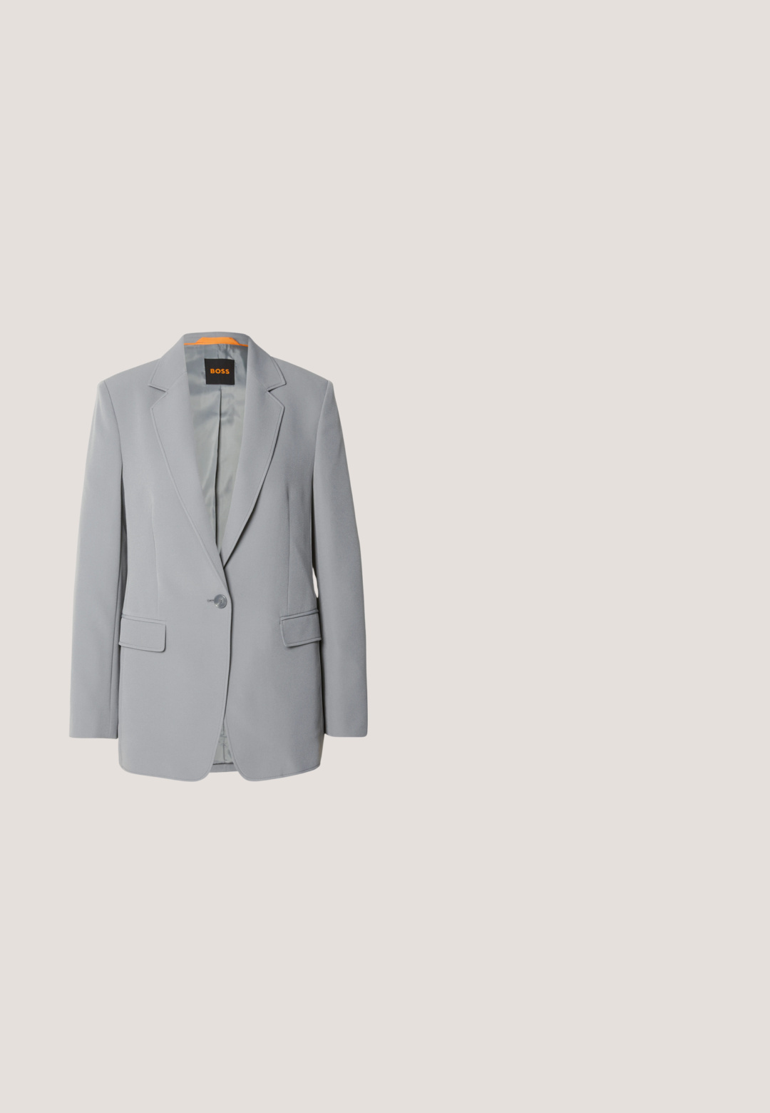 Lys grå blazer med en enkelt knaplukning, kliklapeller og to forlommer. Glat tekstur og orange foring indeni.; Beige langærmet skjorte med en stor spidse krave, knaplukning foran og brede manchetter. Lavet af et glat, let stof.; Beige skræddersyede bukser med en tekstureret stof, slim fit, middelhøj talje og lige ben. Lynlås og knaplukning foran.; Cremefarvet højhælet sko med en tynd rem, placeret på en reflekterende gulv nær en metalfilorganisator med papirer.; Kremfarvet rektangulær håndtaske med en enkelt rem og lynlås øverst, med en lille præget logo-plakette foran.; Sølv hoops øreringe med en poleret overflade og DKNY branding, præsenteret mod en simpel hvid baggrund.