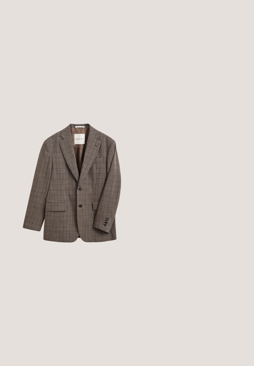 Blazer marron à carreaux à deux boutons avec revers crantés, poches avant à rabat et poignets boutonnés, étiquette GANT à l'intérieur du col.; Cardigan couleur crème en maille torsadée avec col châle, boutonnage devant et deux poches avant, posé à plat sur un fond blanc.; Chemise blanche à manches longues avec boutons en coton, présentant une poche poitrine avec broderie ton sur ton, un col et des poignets boutonnés.; Pantalons en velours côtelé marron avec une coupe évasée, présentant une texture rayée verticale, une fermeture à bouton et des passants de ceinture standard.; Chaussure habillée en cuir marron avec des détails en brogue, bout arrondi et semelle en caoutchouc marron. Dispose de cinq œillets et d'une finition lisse.; Écharpe rectangulaire en laine avec motif à carreaux vert foncé, bleu marine et marron, présentant des lignes rouges, jaunes et blanches et des extrémités à franges.