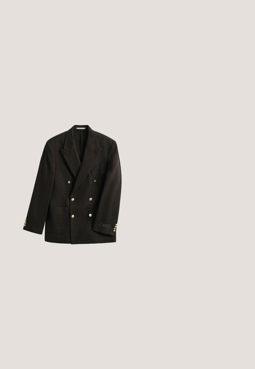 Blazer croisé marron foncé avec larges revers, boutons dorés, poche plaquée et petite étiquette sur le poignet de la manche gauche.; Gilet sans manches en maille avec col en V, présentant des rayures horizontales gris, jaune, orange et marron avec des motifs géométriques.; Chemise blanche à manches longues boutonnée avec un col, petit logo brodé sur la poitrine et ourlet arrondi.; Tissu en velours côtelé marron présentant des côtes verticales, une texture douce et une couleur profonde et riche, adapté pour le rembourrage ou les vêtements.; Mocassins en cuir marron avec un bout légèrement pointu, un petit talon empilé et des coutures décoratives sur le dessus. Texture lisse, design minimaliste.; Serviette en cuir marron avec deux poches avant à boucles, bords cousus et une poignée supérieure, sur fond blanc.