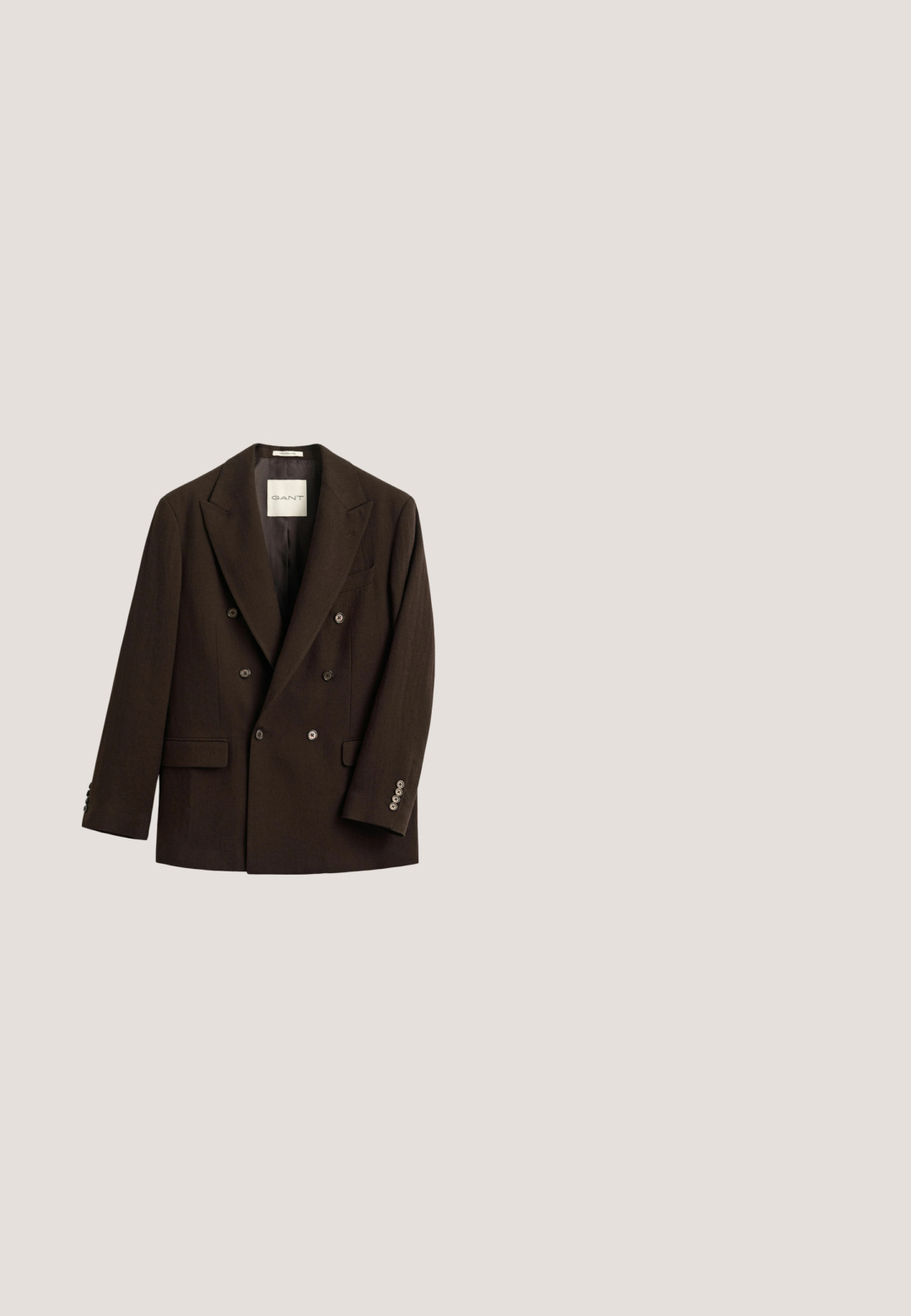 Donkerbruine dubbelgeknoopte blazer met brede revers, zes knopen aan de voorkant, twee klepzakken en vier knopen aan elke manchet.; Bruine coltrui van zacht materiaal, met lange mouwen en een ribgebreide kraag. Glad oppervlak met een aansluitend ontwerp.; Bruine broeken met een recht model, voorzien van een enkele zijplooien, een knoopsluiting en een gladde stoftextuur.; Bruine leren loafers met een gladde afwerking, decoratieve franjes, een ronde neus en een lage zwarte rubberen zool.; Bruine en beige geruite wollen sjaal met franjes aan de uiteinden en subtiele geborduurde tekst nabij de onderrand op een effen achtergrond.; Bruine leren boodschappentas met klep, twee gespsluitingen en verstelbare schouderriem op een witte achtergrond.