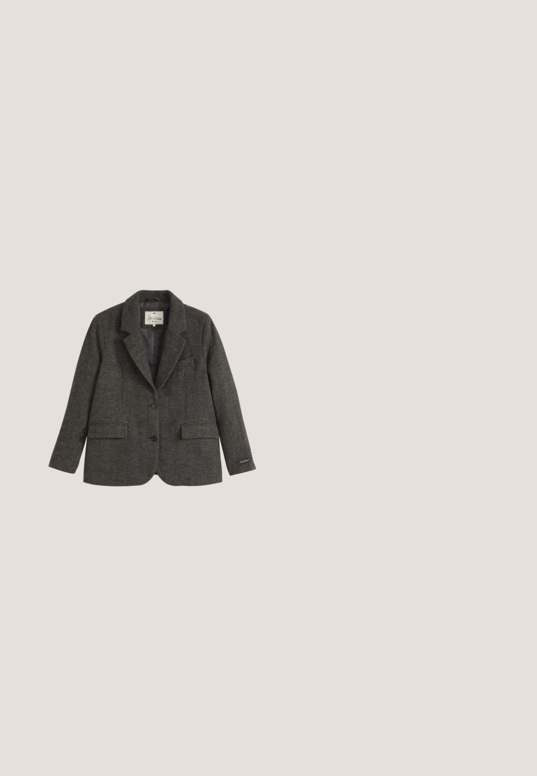Grå tweed blazer med klapkraver, to frontlommer og to knapper. Har en glat foring og et sidelabel med brandlogo.; Grå knap-op skjorte lavet af blødt stof, med krave, lange ærmer, en brystlomme og en knap-lukning ved ærmerne med logo detaljer.; Grå skræddersyede bukser med flad front, lige ben og subtil tekstur; har sidelommer og en glat linning.; Sorte læderankelstøvler med et elegant design, rundet tå, elastiske sidepaneler og kraftige, teksturerede gummisåler.; Sort lædertaske med to håndtag og kontrastfuld hvid syning, med en bred, struktureret form og detaljer med central søm.; Sølvkæde med en lille vedhæng formet som bogstavet "S" og en justerbar lås i enden.