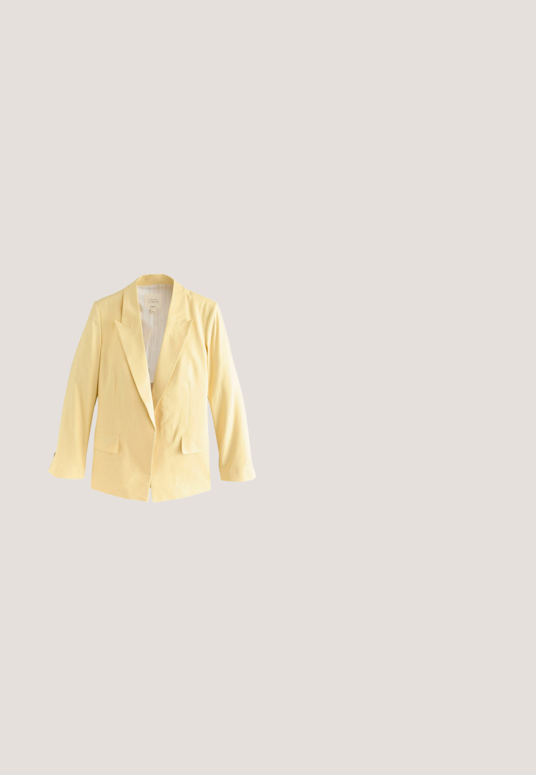Blazer en lin jaune avec un col cranté et une doublure intérieure rayée. L'étiquette indique la composition du matériau et la marque.; Top court crème sans manches avec col montant, devant croisé et quatre boutons métalliques sur l'épaule gauche.; Pantalon beige à jambes larges avec une taille élastique et de grands imprimés floraux jaunes, gris et marron dispersés sur le tissu.; Espadrille beige tissée à enfiler avec semelle plate en jute tressé et petite étiquette de marque marron clair sur le côté.; Sac à main beige avec un panneau crème texturé présentant un motif de logo subtil. Accents en cuir marron avec deux poignées et une bandoulière amovible.; Bague ovale brillante de ton or avec un centre creux en forme de goutte allongée, sur un fond blanc uni.