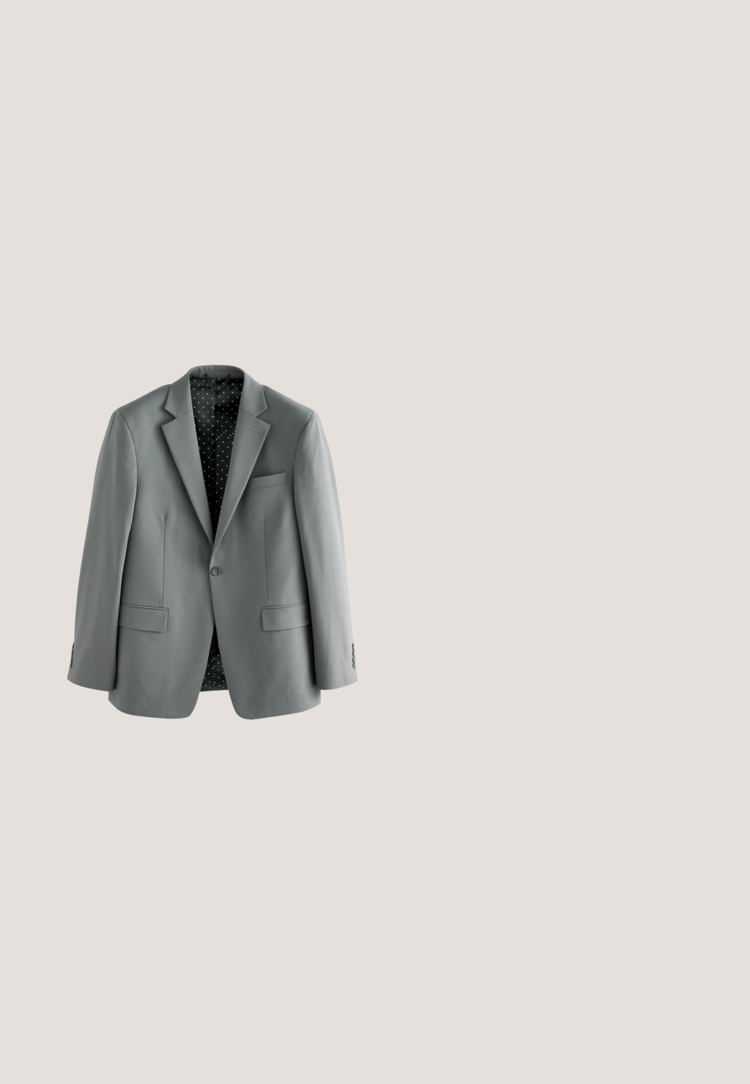Grå blazer med klapkrave, to forlommer og indvendig polka dot mønster. Glat stof med knaplukning.; Hvid skjorte med lange ærmer og spids krave kombineret med et mørkegrønt slips med et diskret prikmønster, vist på en hvid baggrund.; Grå formelle bukser med frontlynlås, bæltestropper og sidelommer, vist fladt mod en hvid baggrund.; Sorte lædersko med rund tå, snøredetaljer og en tekstureret sål med godt greb. Den glatte finish forbedrer det samlede design.; Sort læderpung med en glat tekstur, der har en lynlåslukning på toppen og prægede logodetaljer foran. Kompakt rektangulær form.; Sort læderbælte rullet sammen med en skinnende sølv rektangulær spænde og flere justeringshuller.