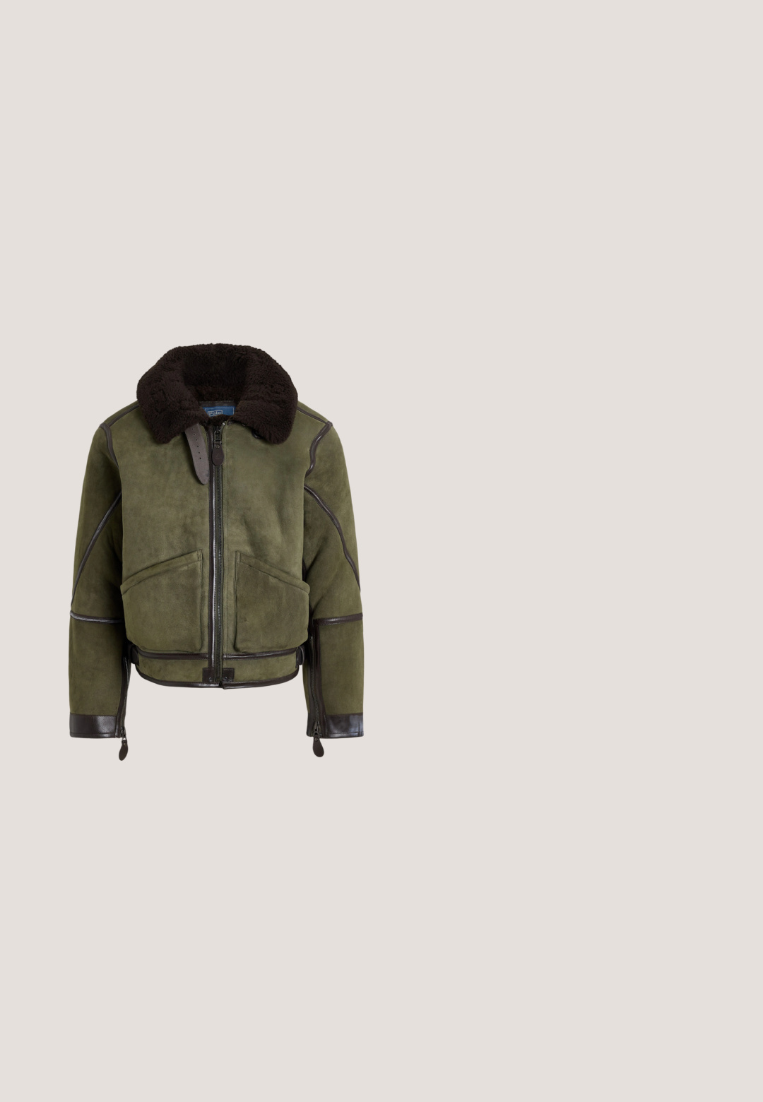 Veste bomber en daim vert olive avec grand col en shearling noir, fermeture éclair devant, deux poches et bordures en cuir sur les bords et les manches.; Pull vert foncé à manches longues avec une fermeture éclair au quart et un col montant, avec un petit logo brodé sur la poitrine gauche.; Chemise bleu clair à manches longues avec boutons, col boutonné, boutons blancs et ourlet arrondi sur fond neutre.; Pantalon en velours côtelé noir, coupe slim, avec de petits logos jaunes brodés éparpillés sur le devant.; Mocassin en cuir noir avec semelle épaisse, bout arrondi et étiquette verte Polo sur le côté.; Ceinture en cuir noir avec une boucle en métal argenté rectangulaire ornée d'un logo embossé de cavalier, texture lisse et cinq trous.