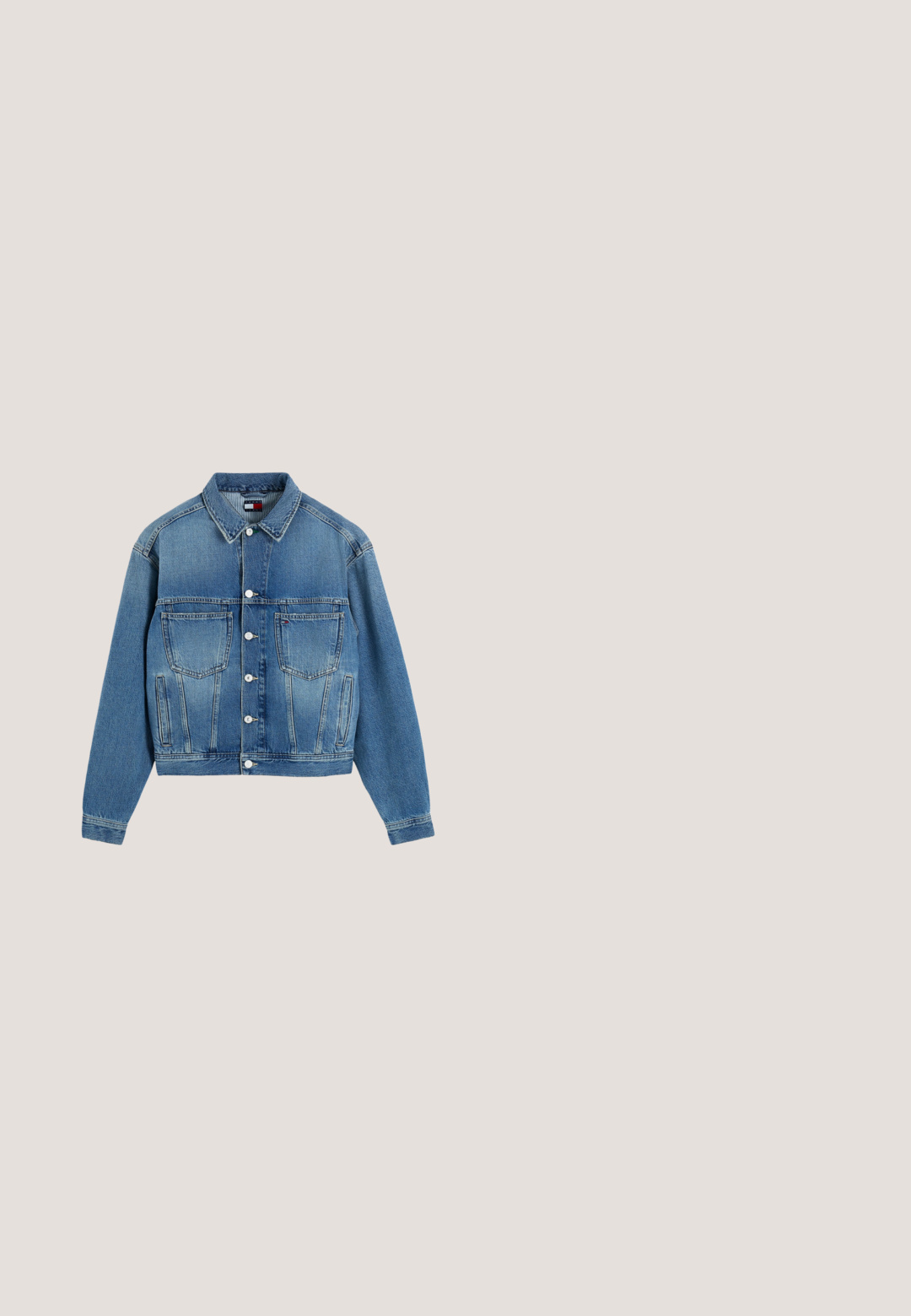 Blauwe spijkerjas met knoopsluiting aan de voorkant, twee borstzakken, zijzakken en een kraag, plat gelegd op een witte achtergrond.; Wit shirt met lange mouwen, horizontale donkerblauwe strepen en een klein Tommy Hilfiger-logo op de linkerborst.; Wijde denim jeans in een donkerblauwe wassing, met een knoopsluiting, vijf zakken en een lichte vervaging in de textuur voor extra detail.; Zwarte leren enkellaars met puntige neus, blokhak en klein gouden logo nabij de bovenzijde aan de buitenkant.; Een paar kleine oorstekers in goudkleur, in de vorm van een hart met een verticale lijn en gegraveerde tekst aan elke zijde.; Zwarte rechthoekige schoudertas met korte strap en Tommy Jeans-logo in rood, wit en blauw op de voorkant in het midden.