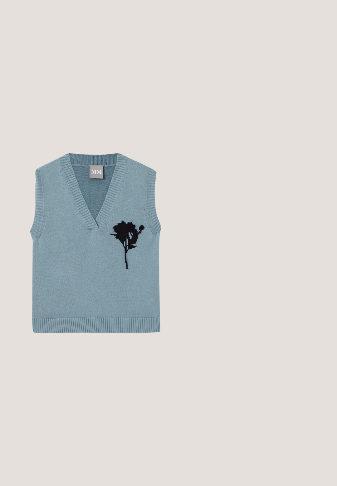 Pull sans manches en tricot bleu avec un col en V, présentant une broderie florale noire sur le devant. Encolure et ourlet côtelés.; Chemise à manches longues boutonnée avec rayures verticales noires et blanches, col classique et logo brodé discret sur la poitrine.; Short en denim bleu foncé avec bouton avant, fermeture éclair, passants de ceinture, poches avant et coutures visibles sur fond blanc.; Chaussure à talon haut en cuir brun foncé avec bout carré et accent doré, lévitant au-dessus d'une surface réfléchissante près d'un organiseur de fichiers en métal.; Lunettes de soleil rectangulaires noires avec verres foncés et détails dorés sur les branches épaisses, présentées sur un fond clair.; Sac à main en cuir noir matelassé avec doubles poignées, accents dorés, pendentif décoratif et logo "GUESS EST 1981" sur le devant.