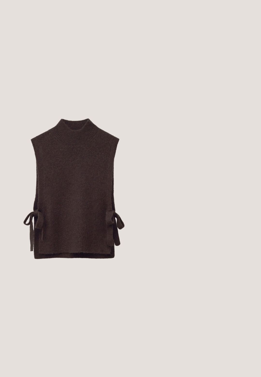 Dunkelbrauner gestrickter ärmelloser Sweater-Westen mit geripptem Stehkragen und seitlichen Bindebändern.; Braune Bluse mit langen Ärmeln und tiefem V-Ausschnitt, befestigtem breiten Halsband und gerafften Bündchen.; Braune, ausgestellte Hosen aus strukturiertem Stoff, mit flachem Vorderteil, Gürtelschlaufen und klassischem Schnitt. Saubere, maßgeschneiderte Linien über das gesamte Kleidungsstück.; Dunkelbrauner strukturierter flacher Schuh mit schwarzem Riemen und goldener herzförmiger Schnalle, Seitenansicht vor hellgrauem Hintergrund.; Schildpatt-Sonnenbrille mit braunen Gläsern, ausgestattet mit goldenen Beschlägen und einem Kristall-Akzent. Katzenaugenform und glatte Kunststoff-Oberfläche.; Dunkelbraune Lederschultertasche mit goldfarbenem Kettenriemen und großem ovalem goldfarbenem Verschluss auf der Vorderklappe.