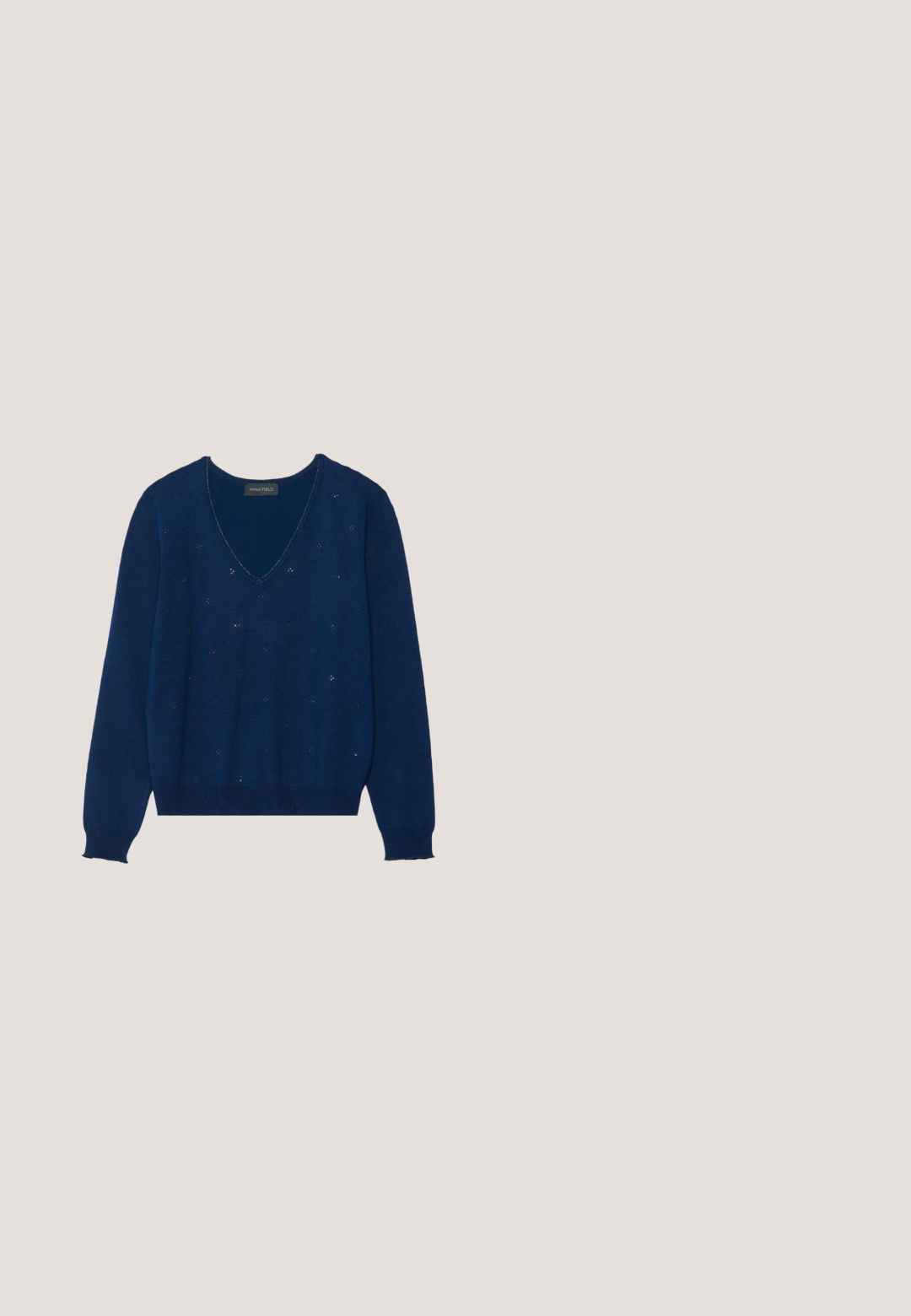 Dunkelblauer Strickpullover mit V-Ausschnitt, langen Ärmeln und subtilen Verzierungen; gerippte Bündchen und Saum; weiche Textur.; Marineblaues Cordhemd mit Knopfleiste, Kragen und Dreiviertelärmeln. Merkmale sind ein taillierter, geraffter Saum und eine weiche Textur.; Marinefarbene Cargo-Hose mit einem Gürtel mit silbernem Ring, vier Taschen und tapered Beinform, aus weichem, strukturiertem Stoff.; Schwarze Wildleder-Loafer mit einem dicken, strukturierten hellbraunen Absatz. Verfügt über ein dezentes Detail mit einem vorderen Riemen. Abgerundete Zehenform mit glatten Kanten.; Schwarze Lederhandtasche mit kurzem Griff, Klappverschluss mit goldfarbener Klammer und abnehmbarem Schulterriemen auf einfachem hellem Hintergrund.; Creolen mit goldfarbenem Ton und ovalen, hellgrünen Edelsteinen, mit polierter Oberfläche und einem schlichten, minimalistischen Design.