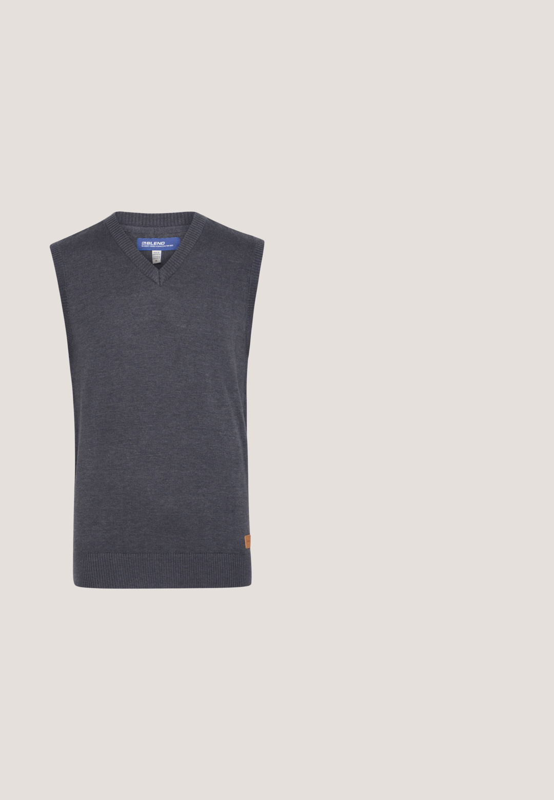 Grijze mouwloze sweater met een V-hals, gemaakt van een gladde brei-stof. Heeft een geribbelde zoom en een klein logo-patch aan de zijkant.;  Lichtblauwe overhemdd met lange mouwen, een kraag en een borstzak. Gemaakt van textiel met een structuur en subtiele patroondetails.; Marineblauwe slim-fit broek van soepel materiaal, met een platte voorkant, riemlussen en een nette afwerking bij de enkels.; Blauwe suède loafer met witte zool en beige stiksels langs de bovenrand, afgebeeld tegen een effen witte achtergrond.; Blauwe stof en bruine leren toilettas met rits en zijhandvat, rechthoekige vorm, "JACK & JONES" label aan de voorkant in het midden.; Marine geweven riem met een zilveren metalen gesp; beschikt over bruine leren accenten en stiksels; gestructureerde stof met een visgraatpatroon.