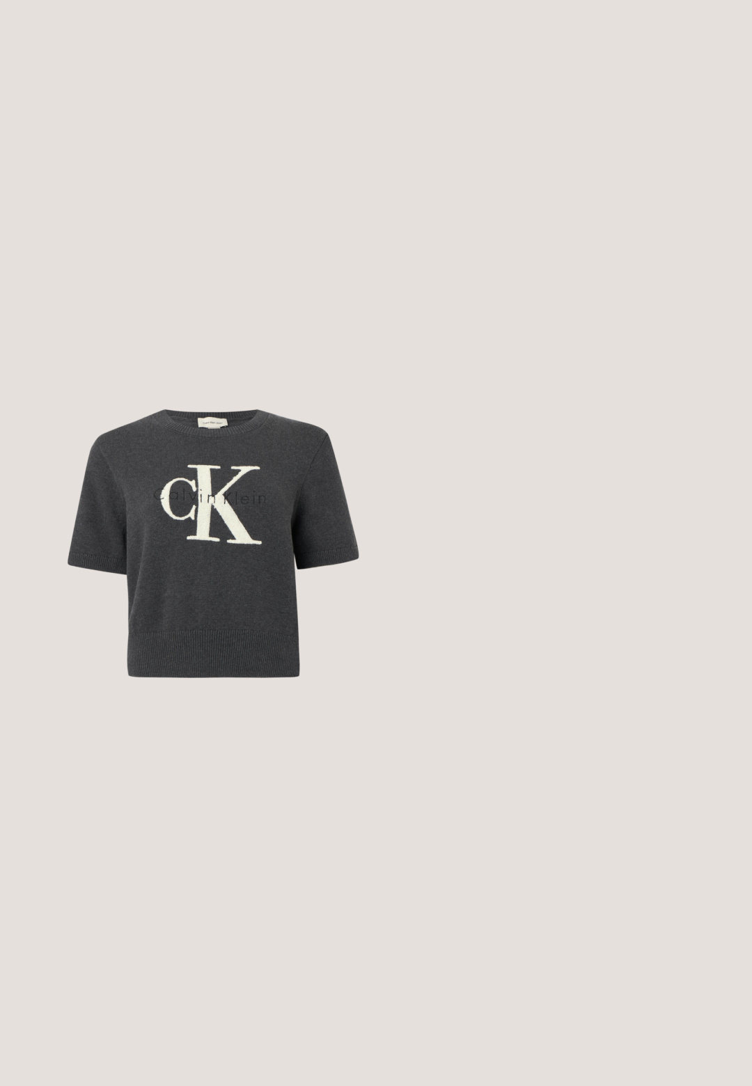 Suéter gris de manga corta con un gran logo blanco "CK" en el frente, con cuello y dobladillo inferior acanalados. Textura de tejido suave.; Replay SHIRT - Blusa - dark grey; Jeans negros de pierna ancha hechos de mezclilla, con cierre frontal de botones, cinco bolsillos y un pequeño parche con el logo en la cintura.; Zapato slingback gris metálico con punta puntiaguda, tacón bajo tipo kitten y correa ajustable sobre fondo blanco.; Bolso de cuero negro con asas largas dobles y logo ovalado en relieve en la parte delantera, mostrado sobre un fondo claro y liso.; Pendientes de aro semicírculo en tono plateado con textura acanalada y cierre de presión sobre fondo blanco.