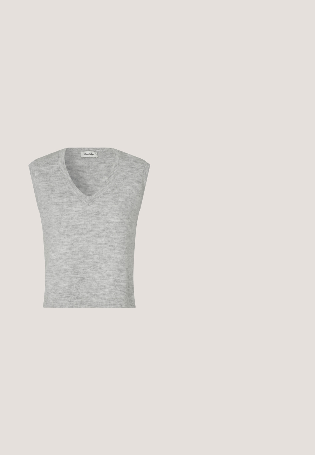 Sivý bezrukávový sveter s výstrihom do V, vyrobený z mäkkého materiálu, s jemnou textúrou a priliehavým strihom.; WE Fashion Blúzka so zapínaním na gombíky - grey; Nohavice so širokými nohavicami v pepito vzore, sivá a čierna farba, s hladkým povrchom a vysokým pásom.; Gino Rossi LOAFERS - Našuchovačky - black; Čierna semišová kabelka s horným držadlom, nastaviteľným ramenným popruhom a ozdobným opaskom vpredu, na bielom pozadí.; Strieborné náušnice s otvoreným kruhovým tvarom, nepravidelnými vlnitými tvarmi a zapínaním na puzetu na bielom pozadí.