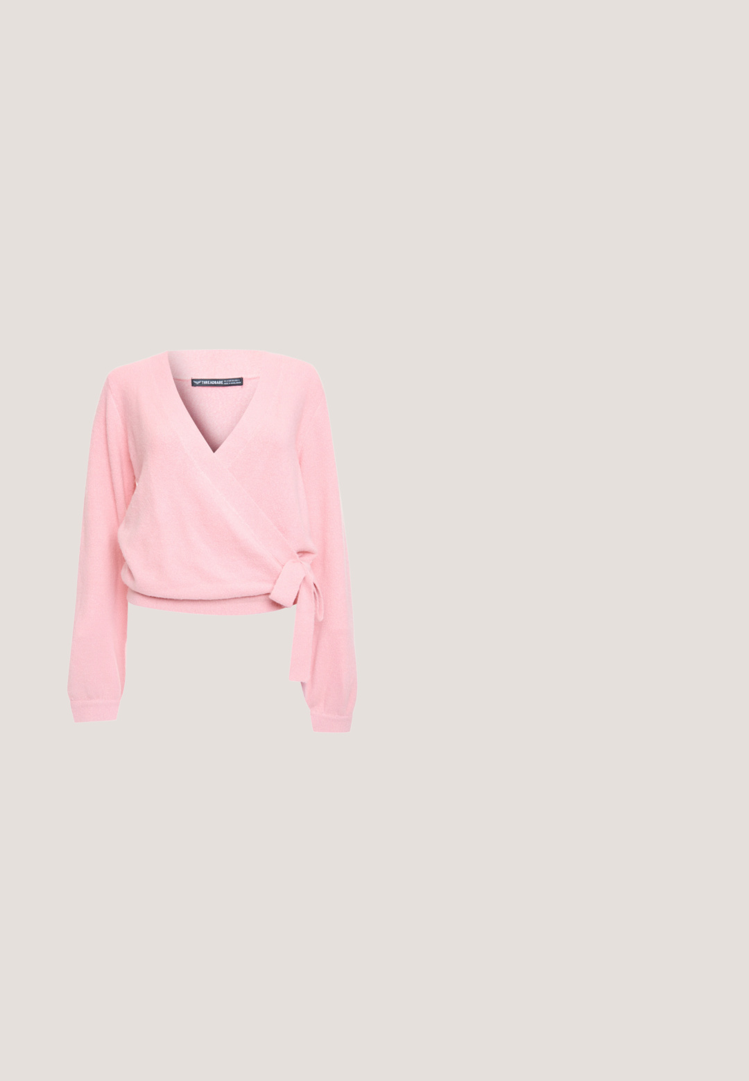 Threadbare Trui - pink; Roze satijnen camisole met verstelbare spaghettibandjes, voorzien van een sluiting met een strik aan de voorkant en een V-halsontwerp. Gladde textuur en strakke lijnen.; Zachte roze satijnen midi-rok met een A-lijn silhouet en soepel, vloeiend stof.; Crèmekleurige leren ballerina met een afgeronde neus, gekruiste enkelriempjes, een klein strikje aan de voorkant en platte zool.; Roze leren crossbodytas met gouden kettingriem en rechthoekige gouden gesp op witte achtergrond.; Roze satijnen scrunchie met kleine decoratieve kralen en een klein stoffen label op een witte achtergrond.