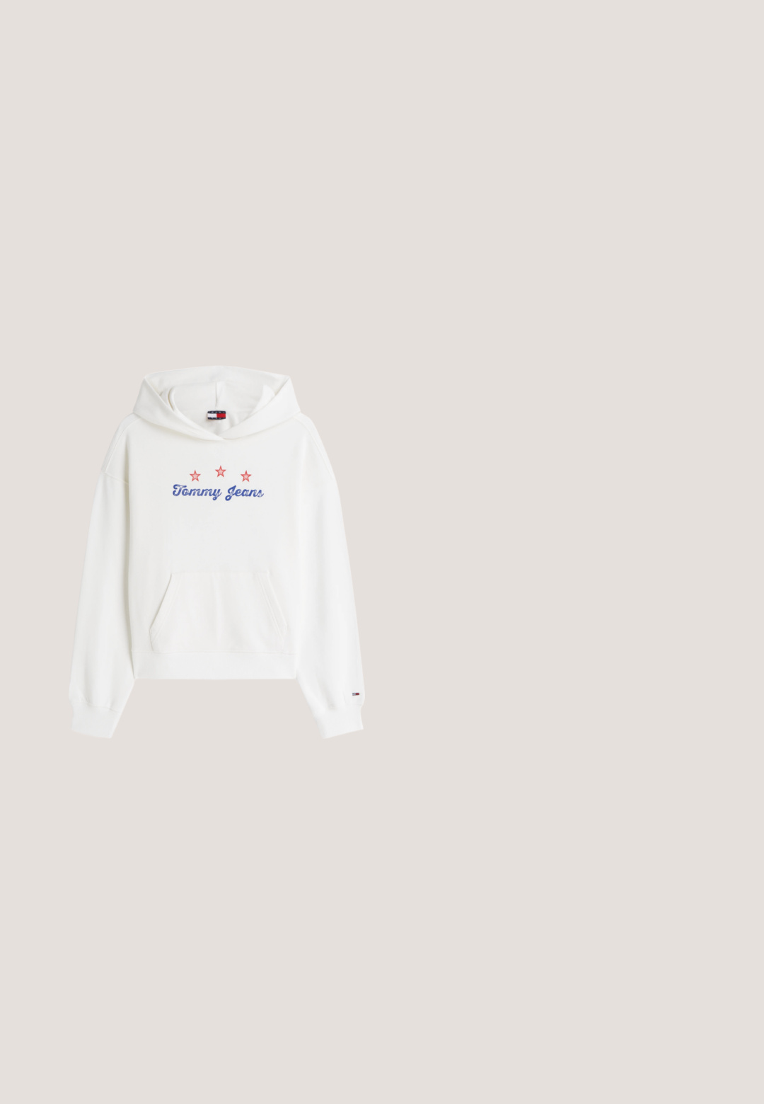 Witte capuchontrui met voorzak, met de tekst "Tommy Jeans" in blauw en drie rode sterren erboven op de borst.; Mouwloos lichtblauw denimvestje met knopen aan de voorkant, een ronde hals, aansluitend lijfje en een gerimpelde zoom.; Lichtblauwe denimjeans met een rechte pijp, voorzien van een rasterpatroon van zilveren studs en een klassieke vijf-pocketontwerp.; Lichtblauwe lage sneaker met een witte plateauzool, witte veters en het Tommy Jeans-logo aan de zijkant en op het label bij de veters.; Gewatteerde blauwe denim schoudertas met zilveren kettingriem, verstelbare gesp en metalen "TH"-logo aan de voorkant.; Zilveren ketting met een dubbele schakel, met een hart hangertje. Het hart heeft een binnen uitgesneden vorm en een schuifslot.