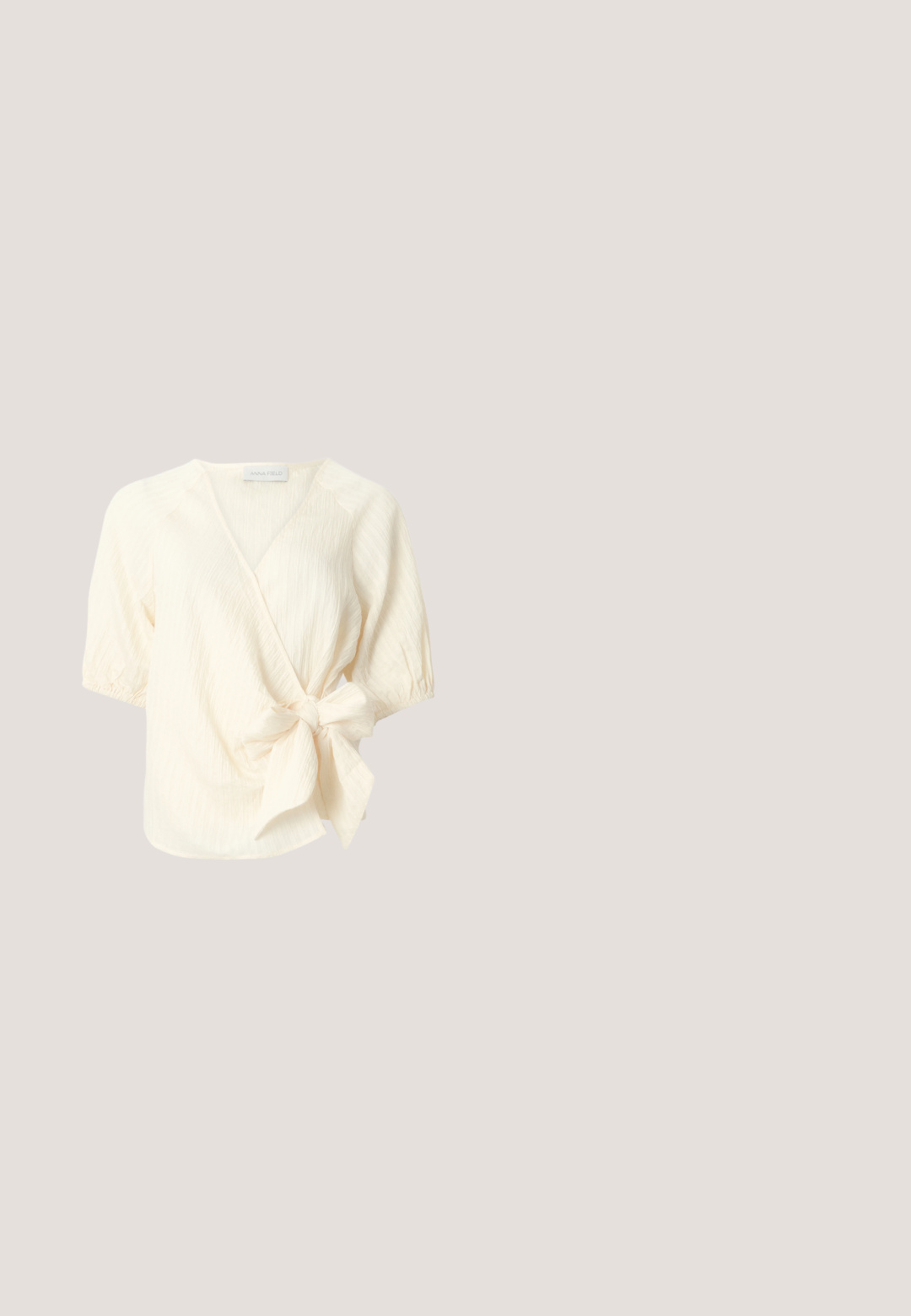 Cremefarbene Wickelbluse mit kurzen Ärmeln aus strukturiertem Stoff und großer seitlicher Schleife in der Taille.; Ein cremefarbener Midikleidrock mit Falten, einer Knopfleiste vorne und einer glatten Textur, entworfen für eine legere Passform.; Spitz zulaufender, cremefarbener Pumps mit Blockabsatz. Verfügt über ein dünnes Knöchelriemchen mit einer runden Schnalle und einer glatten Lederoberfläche.; Transparente beige rechteckige Brille mit klaren Gläsern auf einer weißen Oberfläche liegend.; Kleine über die Schulter tragbare Tasche in Beige und Weiß mit geometrischen Mustern, Lederbesatz, vorderem Riemen mit goldfarbenem Schnallenverschluss und verstellbarem Schulterriemen.; Zarte doppellagige goldene Halskette mit gleichmäßig verteilten kleinen weißen Perlen auf schlichtem hellem Hintergrund.